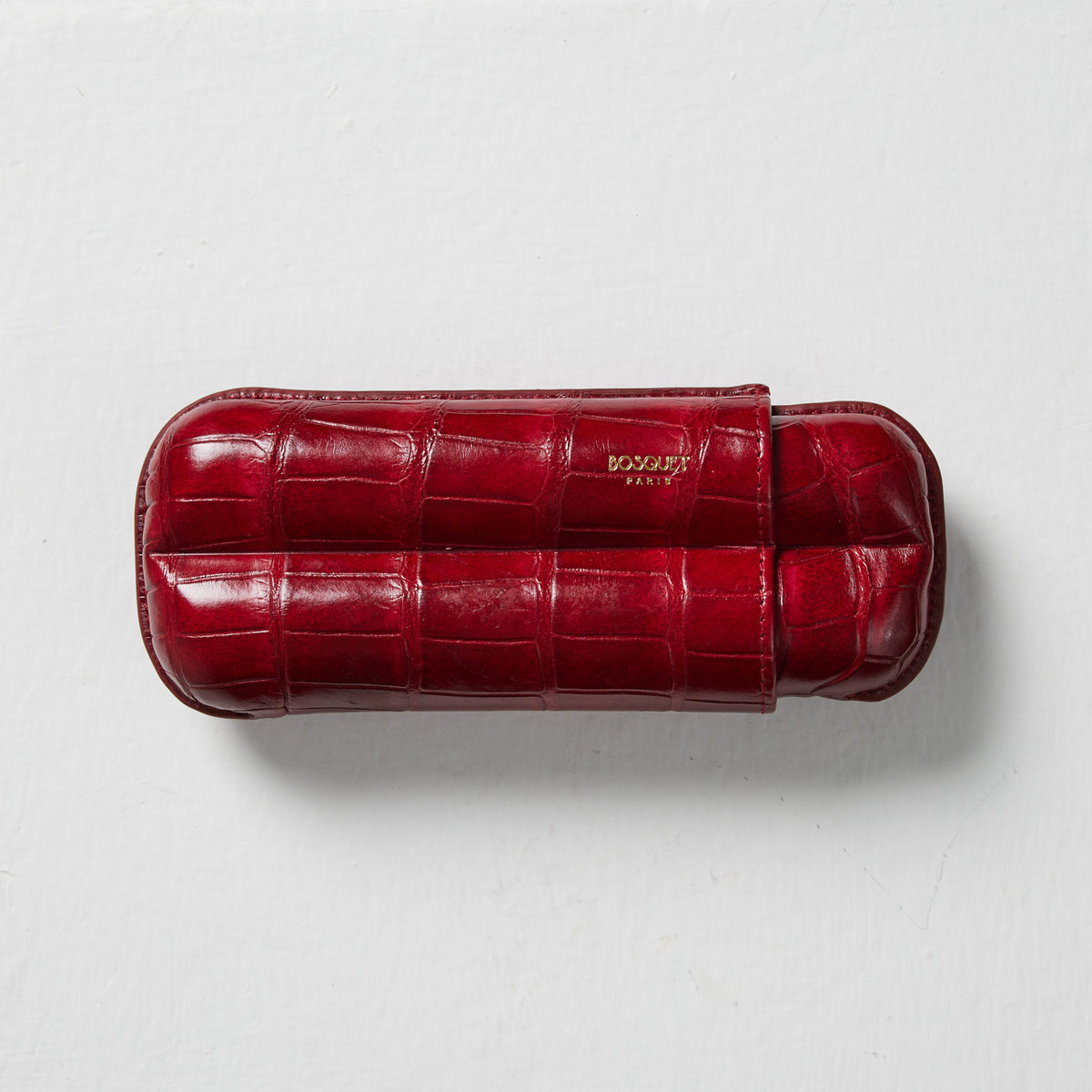 A Bosque Crocodile Cigar Case in Hermes Red on a white surface.