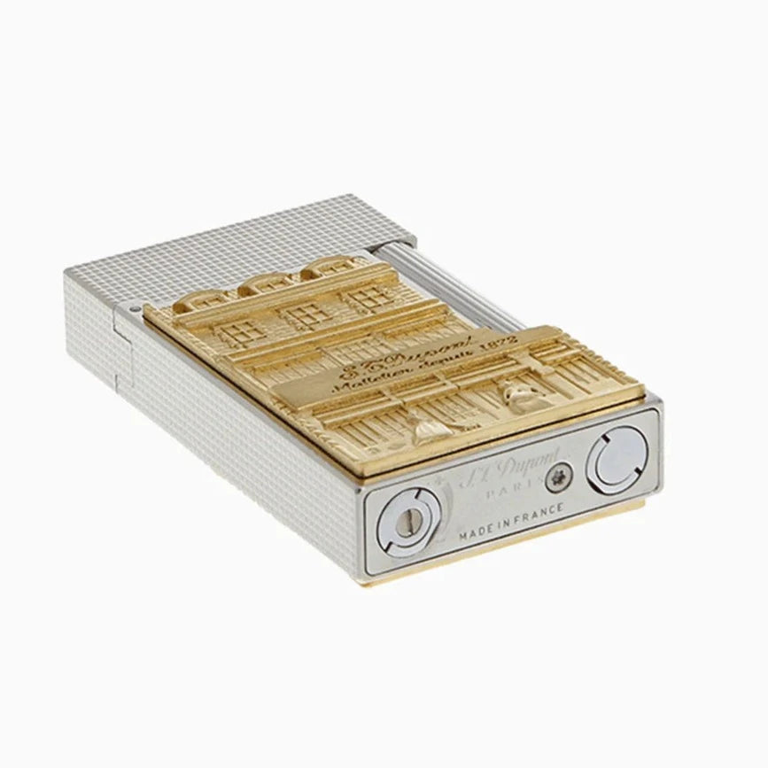 A small box with a gold and white design on it, inspired by the S.T. Dupont Line 2 Hotel Particulier Lighter from the brand S.T. Dupont.