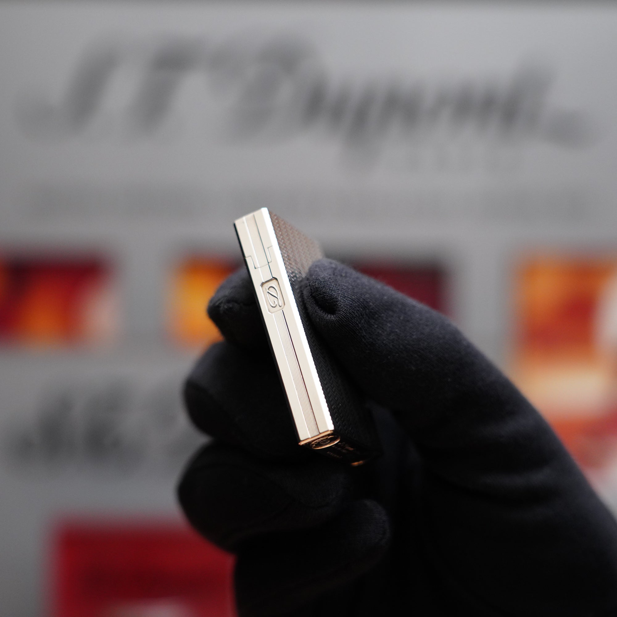 A Vintage 1980 S.T. Dupont Ligne D Heavy Silver Plated Lighter Fine Wave Type Lighter in a hand held in front of a sign.