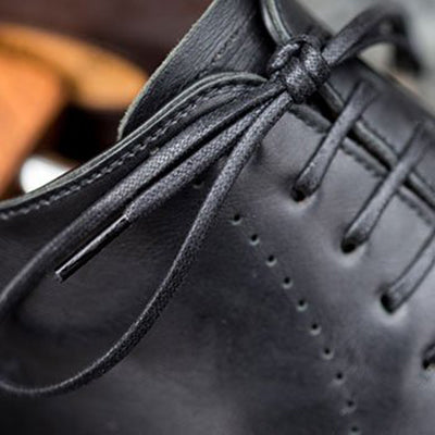 A close up of a black leather shoe.