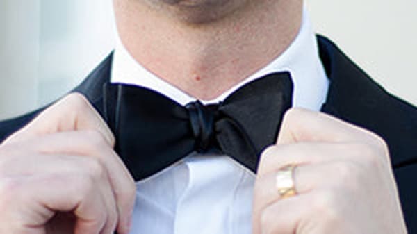 Close up of a man tightening his bow-tie from both sides