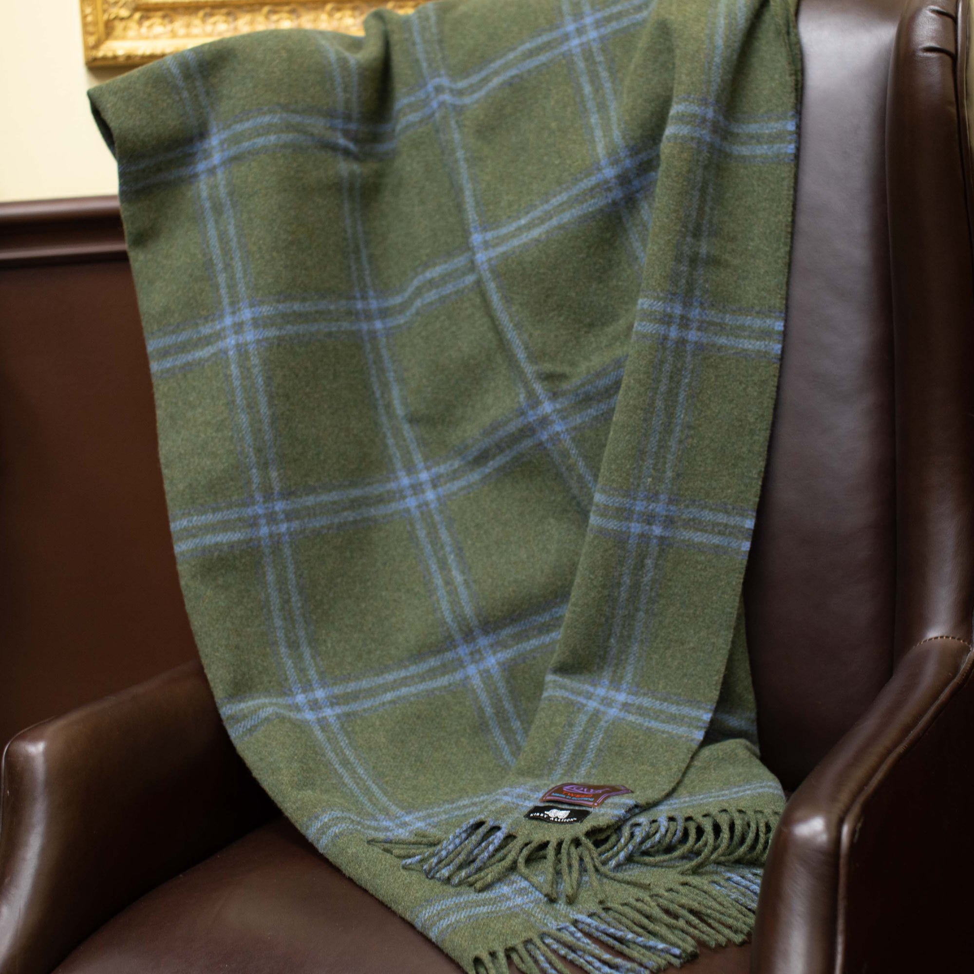 A Kirby Allison Lovat Mill Suit to Shoot Tweed Wool Throw is sitting on a chair.
