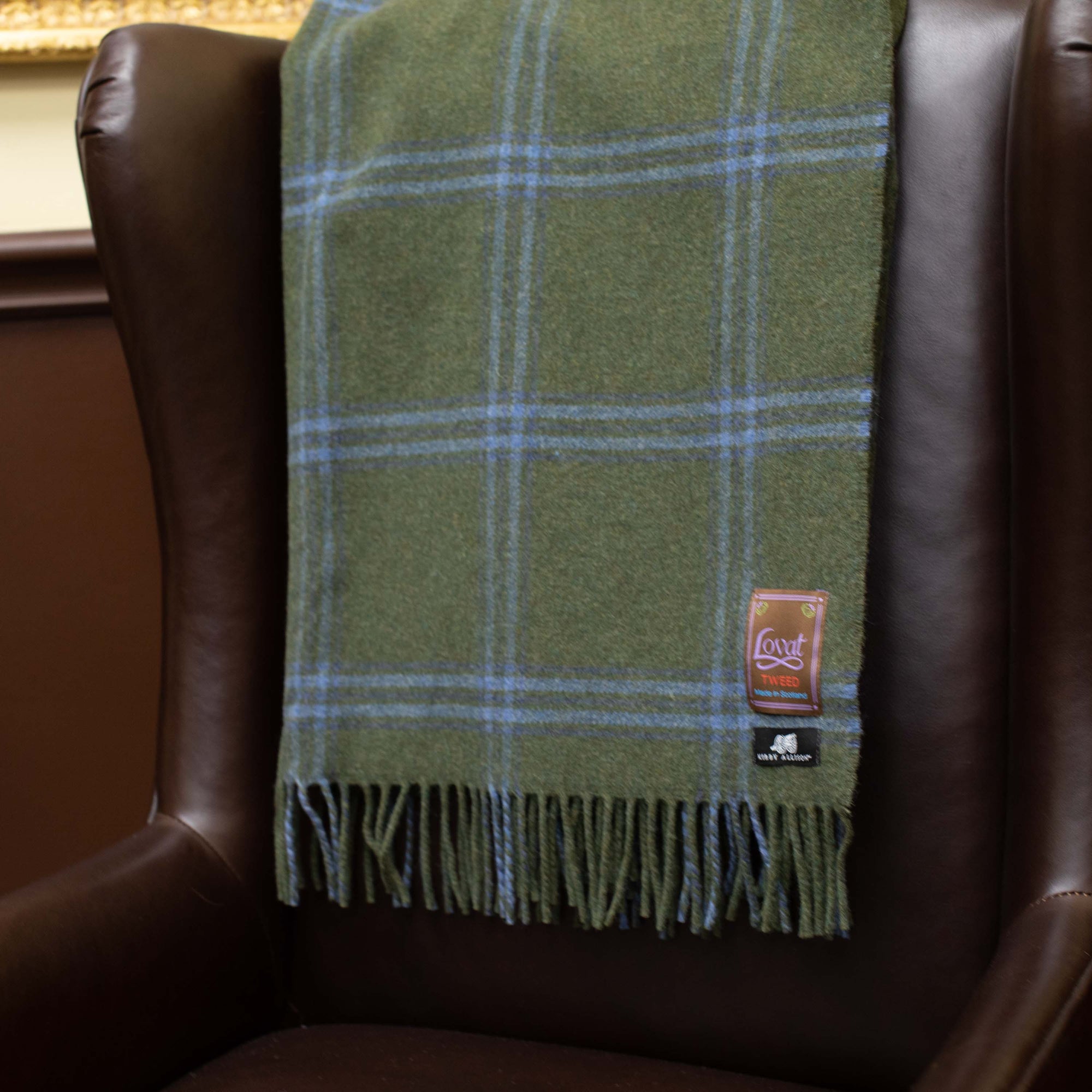 A new Kirby Allison Lovat Mill Suit to Shoot Tweed Wool Throw blanket is sitting on a chair.