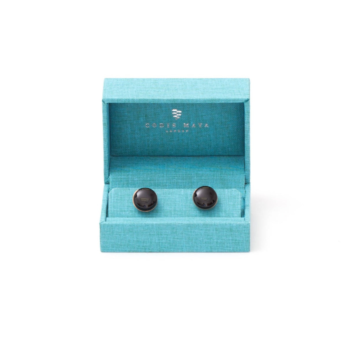 A pair of Onyx Stone Gold Capsule Cufflinks in a blue box from KirbyAllison.com.