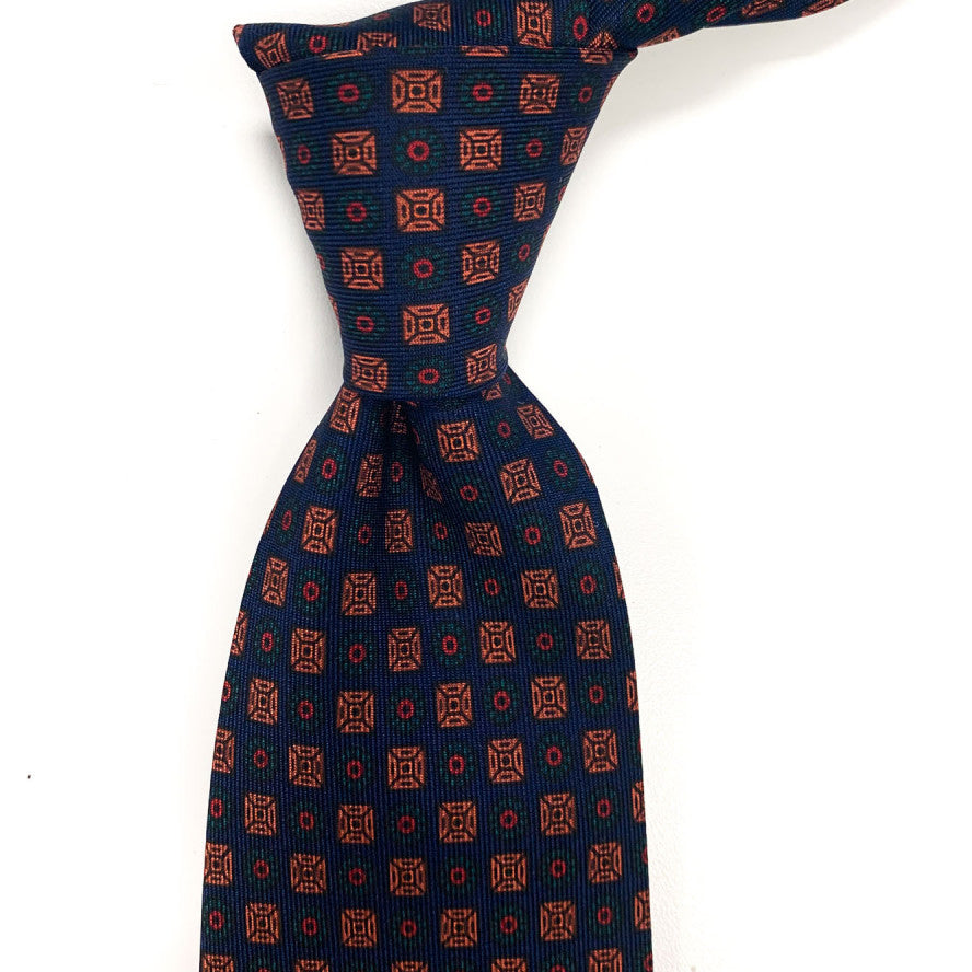 A Sovereign Grade Dark Navy Ancient Madder necktie from KirbyAllison.com with a handmade orange and blue pattern of the highest quality.