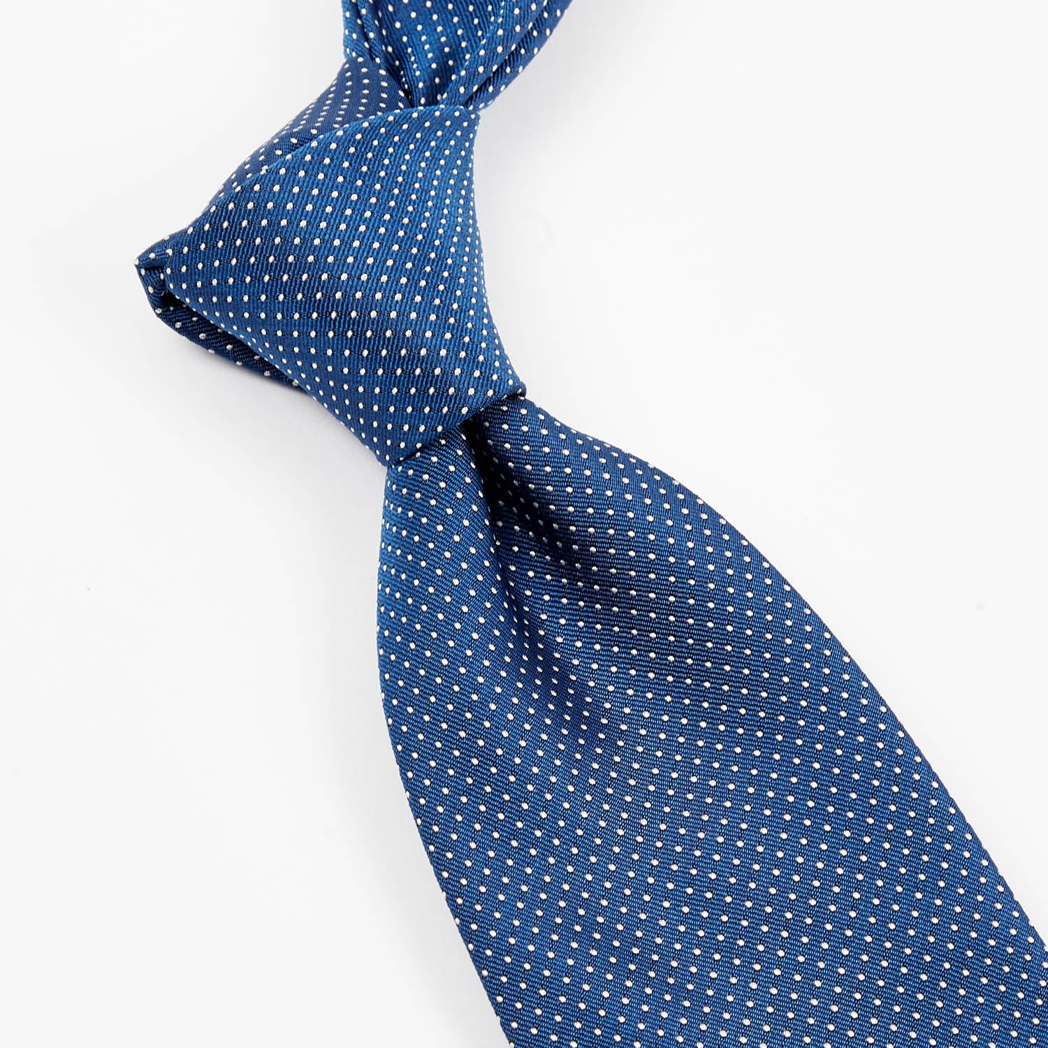 A Sovereign Grade Blue Silk Micro Dot Tie from KirbyAllison.com on a white surface.