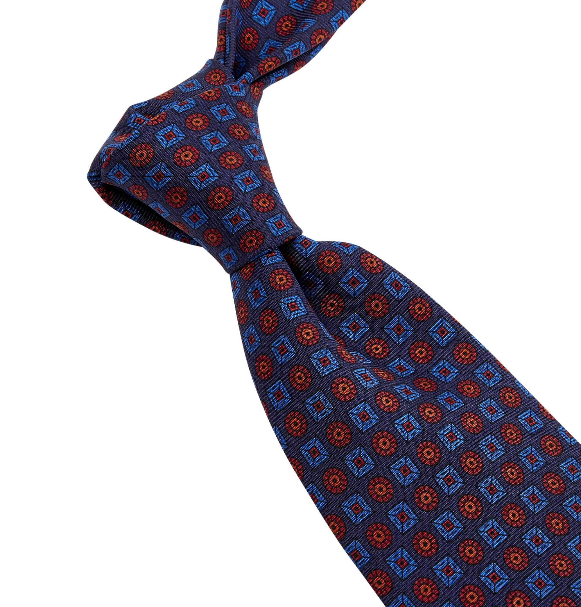 A Sovereign Grade Navy Ancient Madder Tie from KirbyAllison.com, with a blue and red pattern, crafted from 100% English silk.
