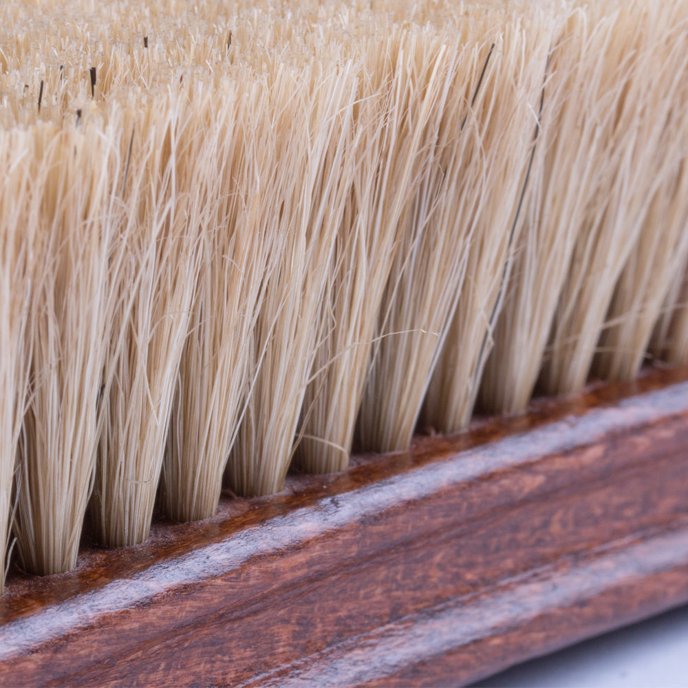 A close up of a Deluxe Wellington Pig Bristle Shoe Polishing Brush with a wooden handle for shoe polishing from KirbyAllison.com.