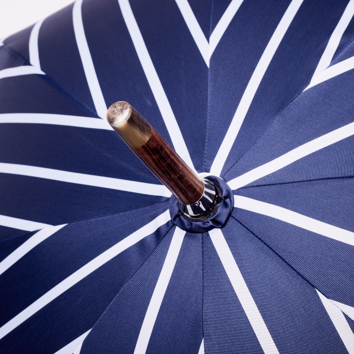 A KirbyAllison.com navy pin stripe umbrella with a bamboo handle.