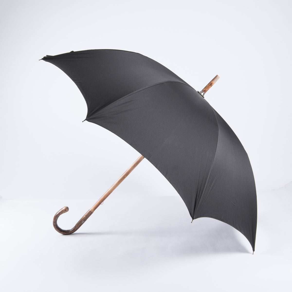 A KirbyAllison.com Walnut Solid-Stick Umbrella with Black Canopy.