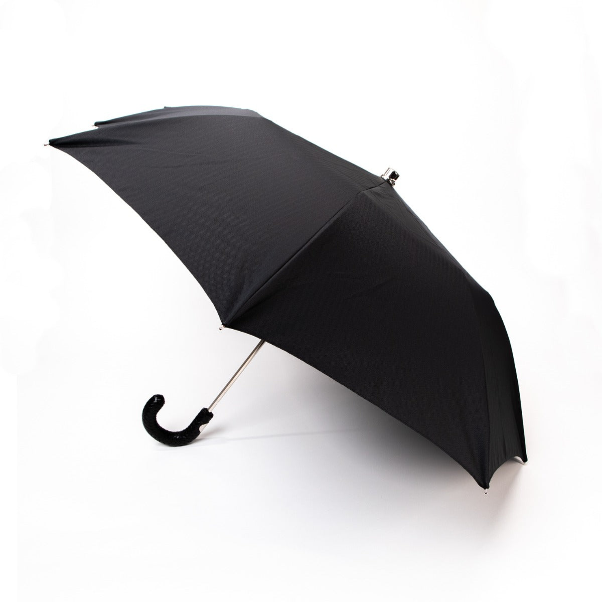 A Black Herringbone Canopy Travel Umbrella with a Woven Leather Handle by KirbyAllison.com in Milan.
