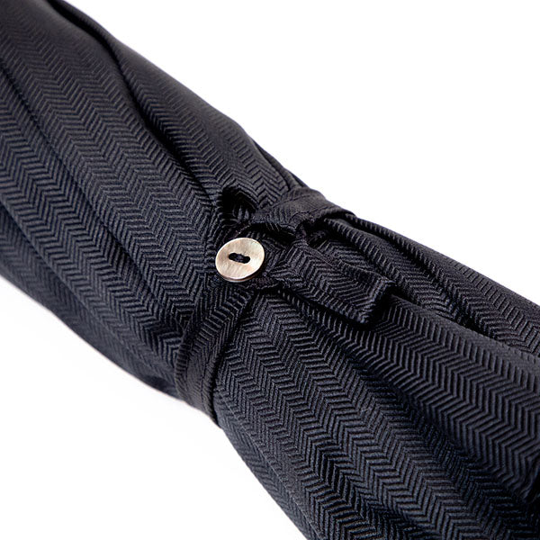 A Black Herringbone Canopy Travel Umbrella with a silver buckle from Milan, Italy by KirbyAllison.com.