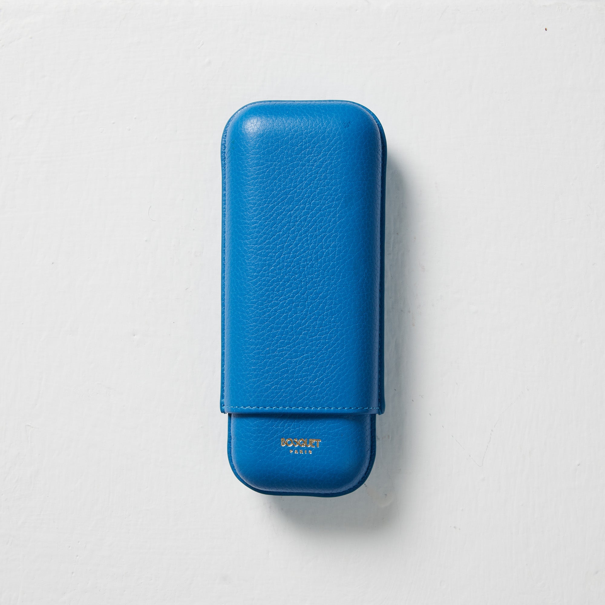 A Bosque Bosquet Smooth Capri Blue Leather Cigar Case sitting on a white surface.