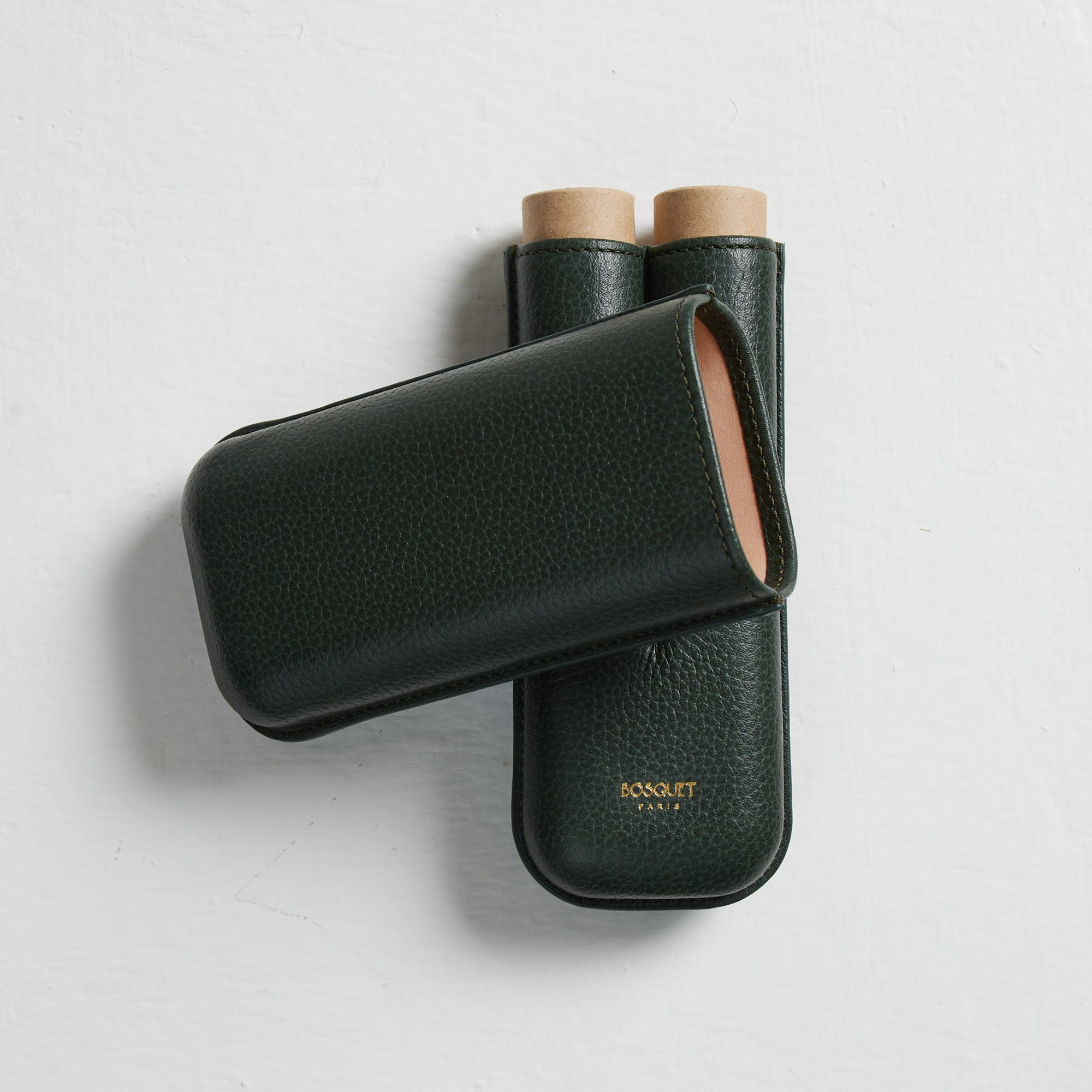 Two Bosque Smooth Forest Green Leather Cigar Cases on a white surface for transporting cigars.
