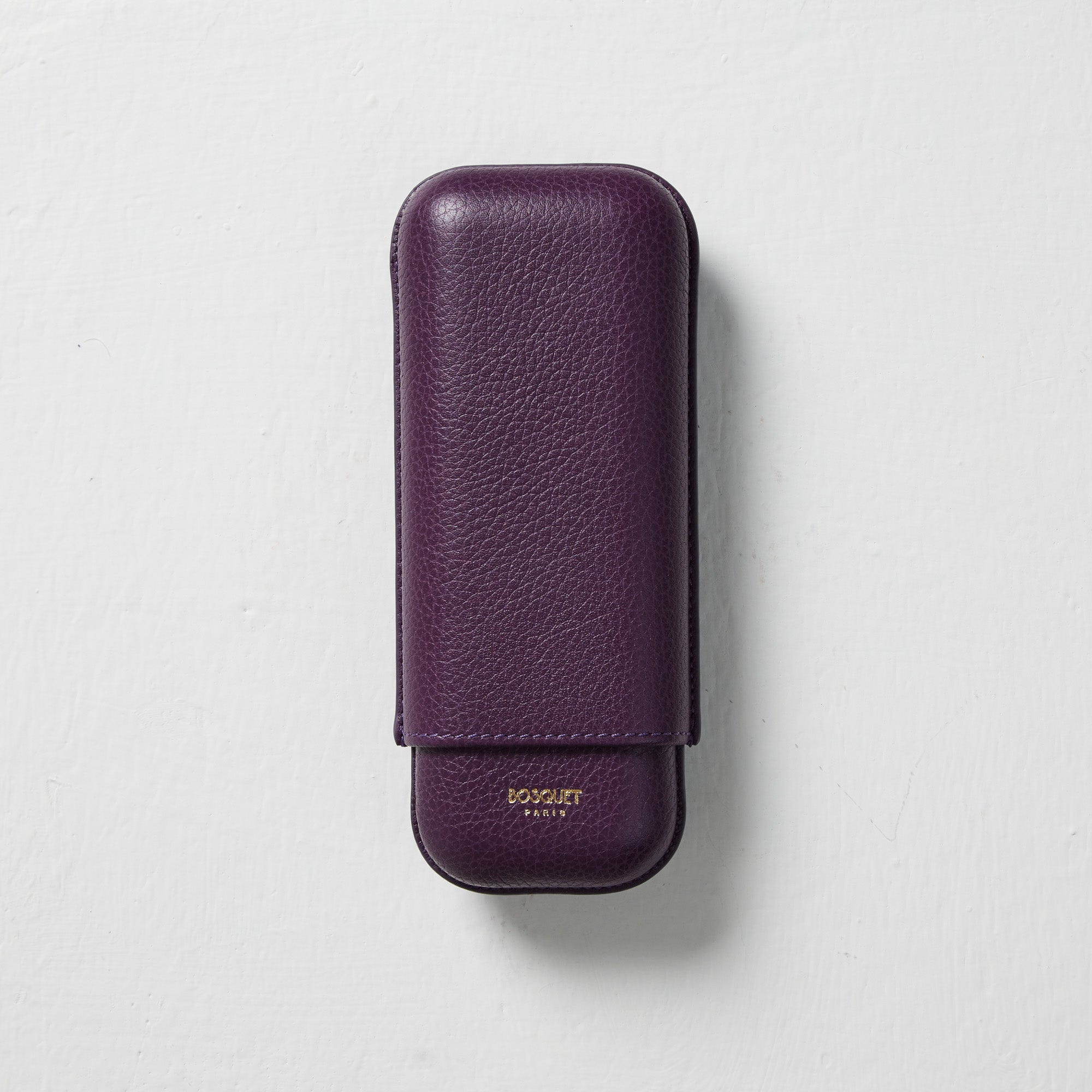 A Bosquet smooth purple leather cigar case in purple on a white surface.
