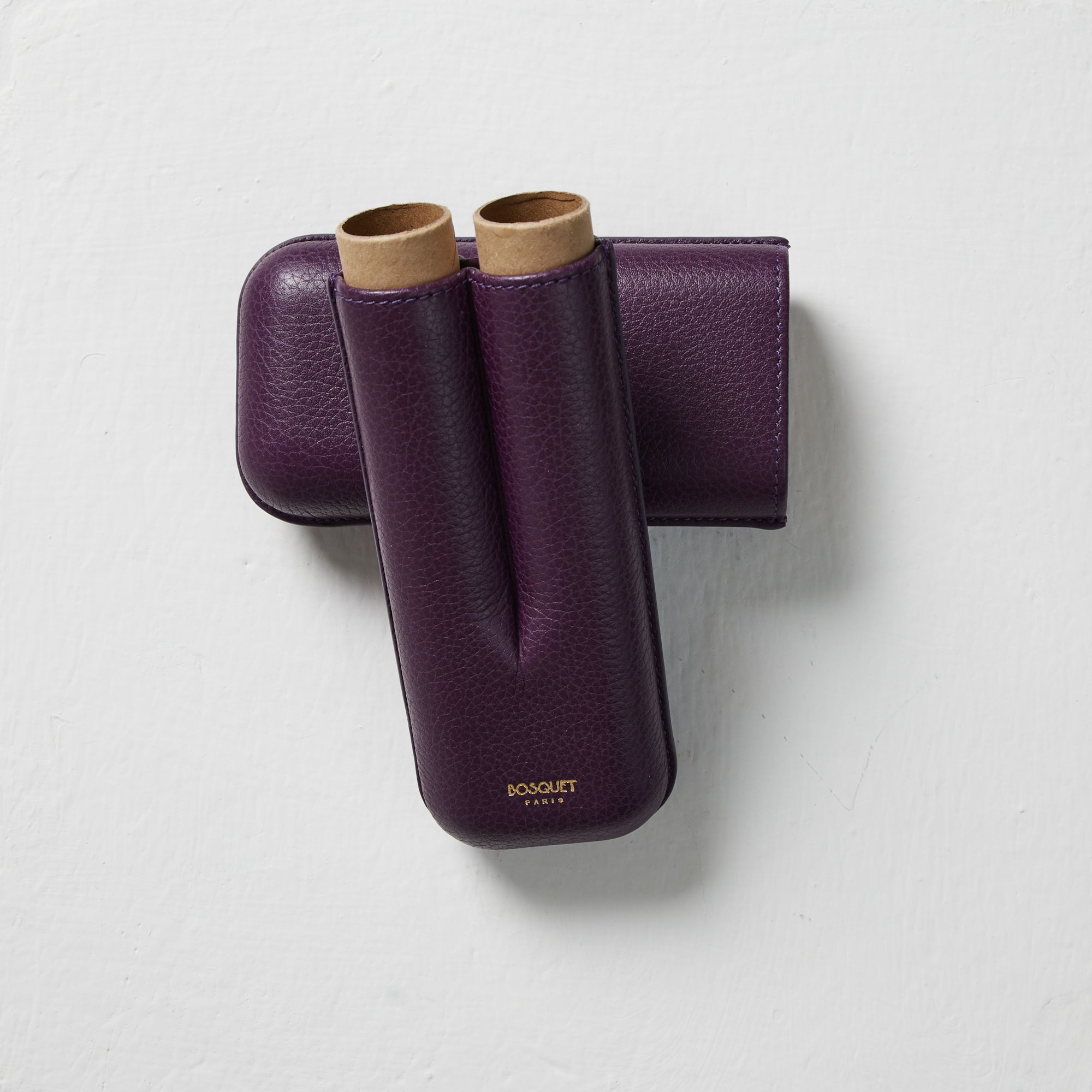 A pair of Bosque Smooth Purple Leather Cigar Cases on a white surface.