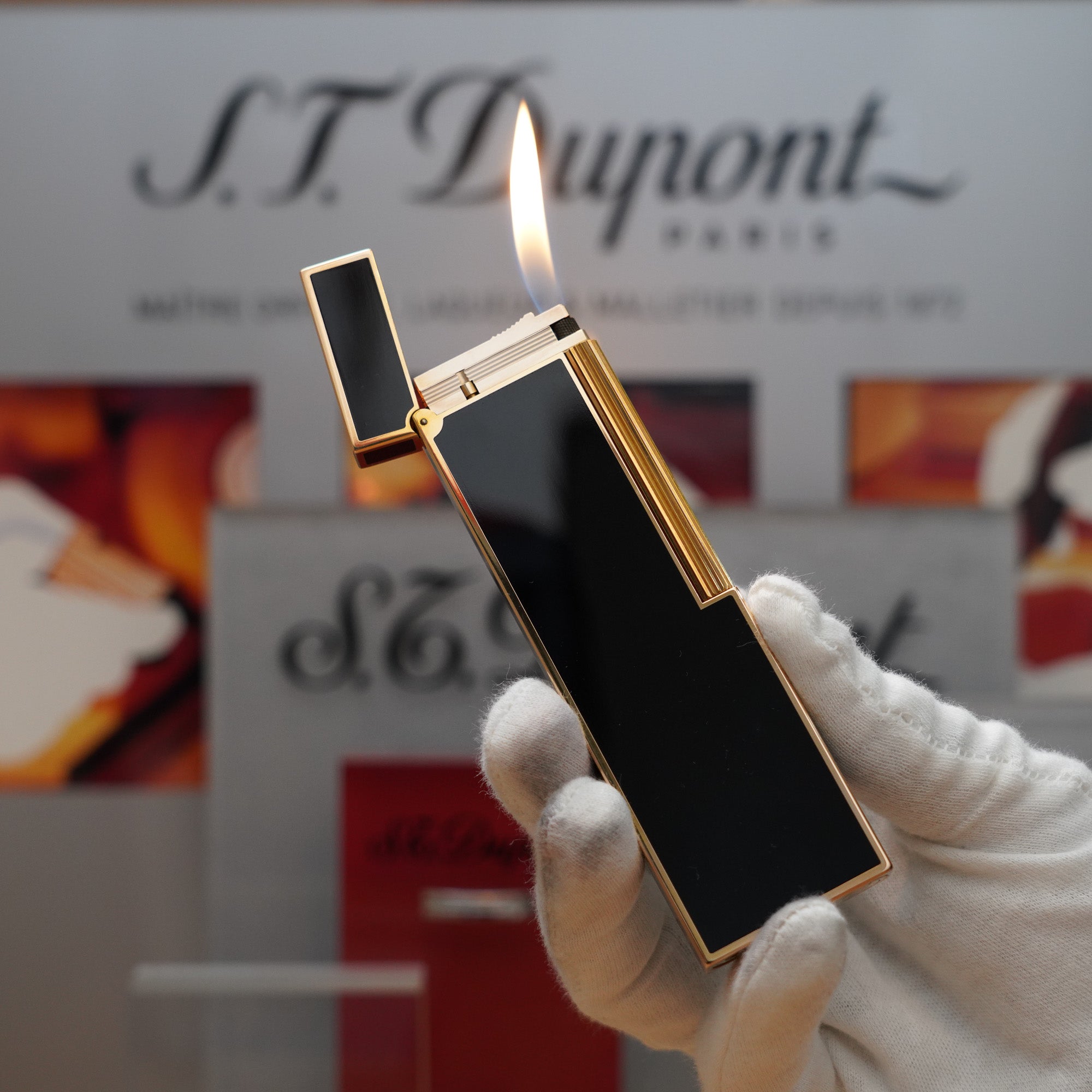 A person is holding a Vintage 1980 S.T. Dupont 18k Gold Plated Ligne 2 Black Lacquer Table Lighter in front of a sign.