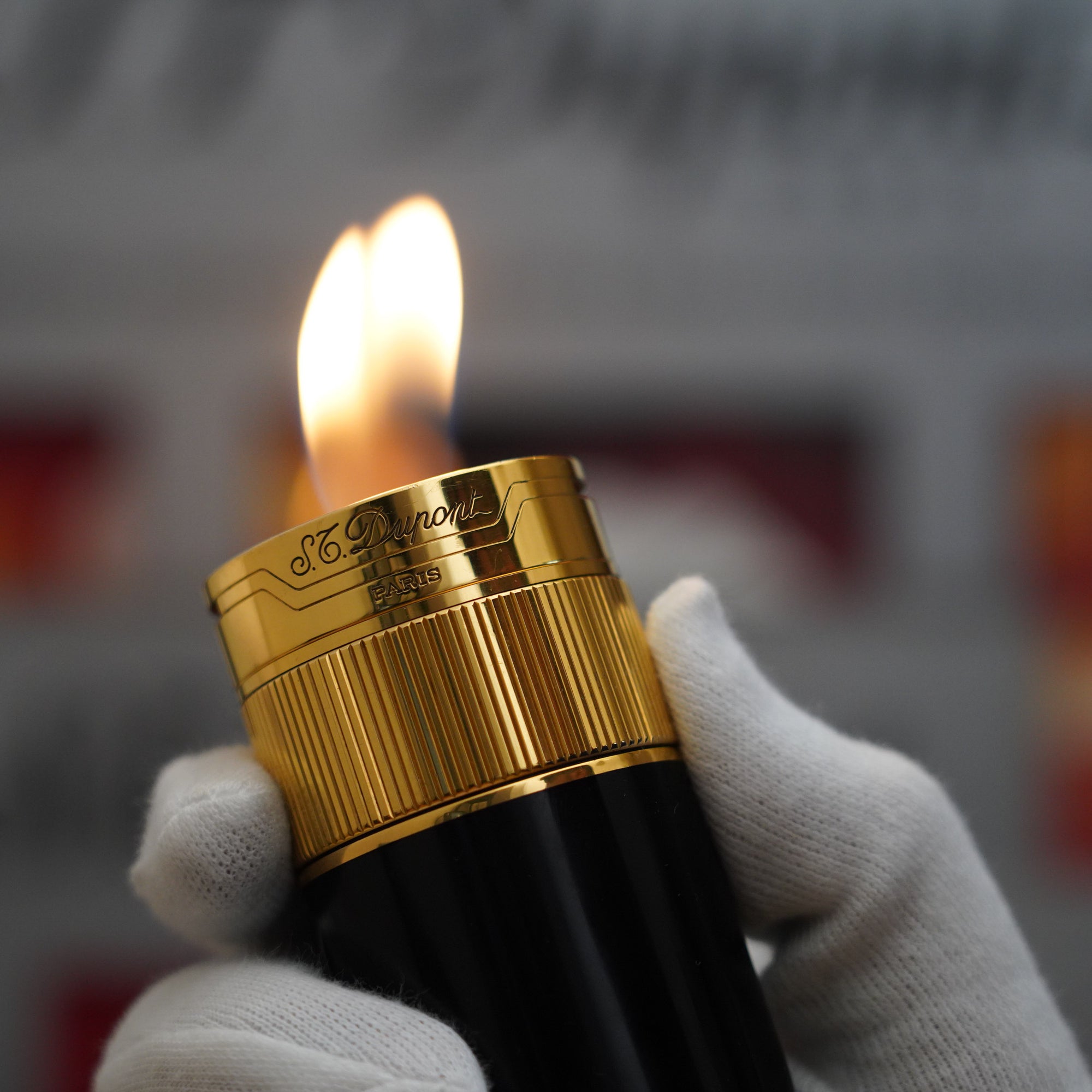 A person is holding a Vintage 1980 S.T. Dupont 18k Unique Cylinder Gold Plated Black Lacquer Dual Flame Table Lighter.