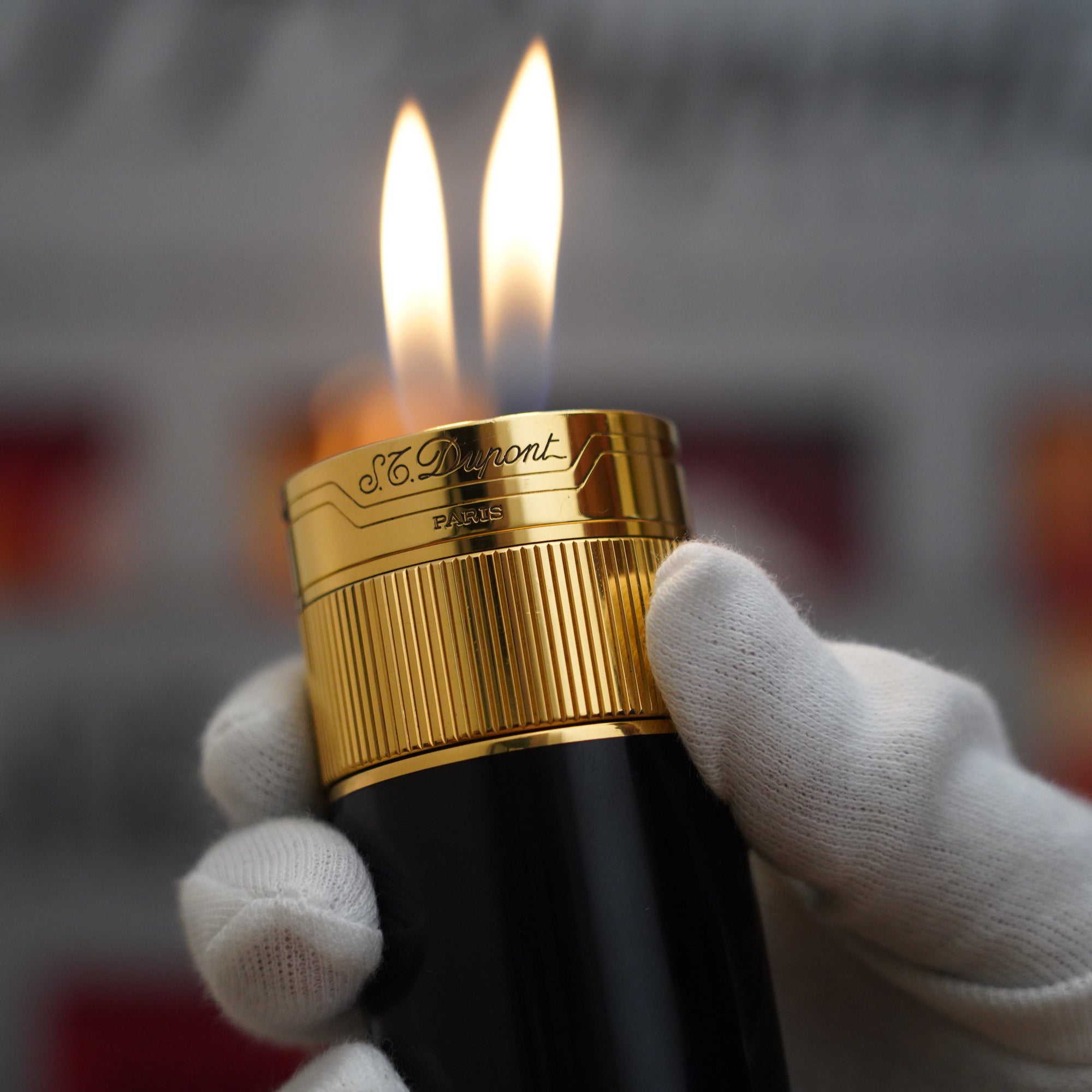 A person is holding a Vintage 1980 S.T. Dupont 18k Unique Cylinder Gold Plated Black Lacquer Dual Flame Table Lighter.