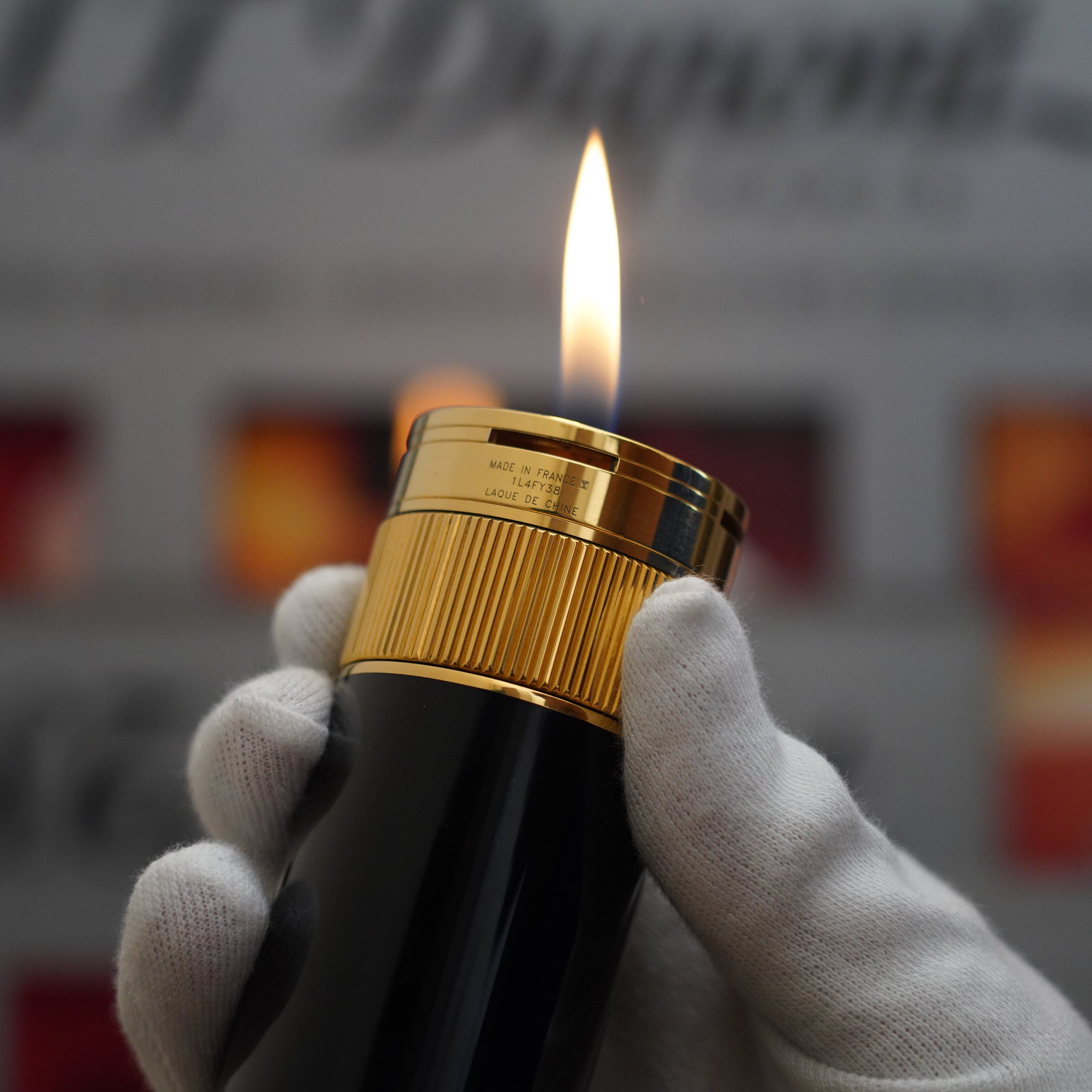 A person holding a vintage 1980 S.T. Dupont 18k Unique Cylinder Gold Plated Black Lacquer Dual Flame Table Lighter.