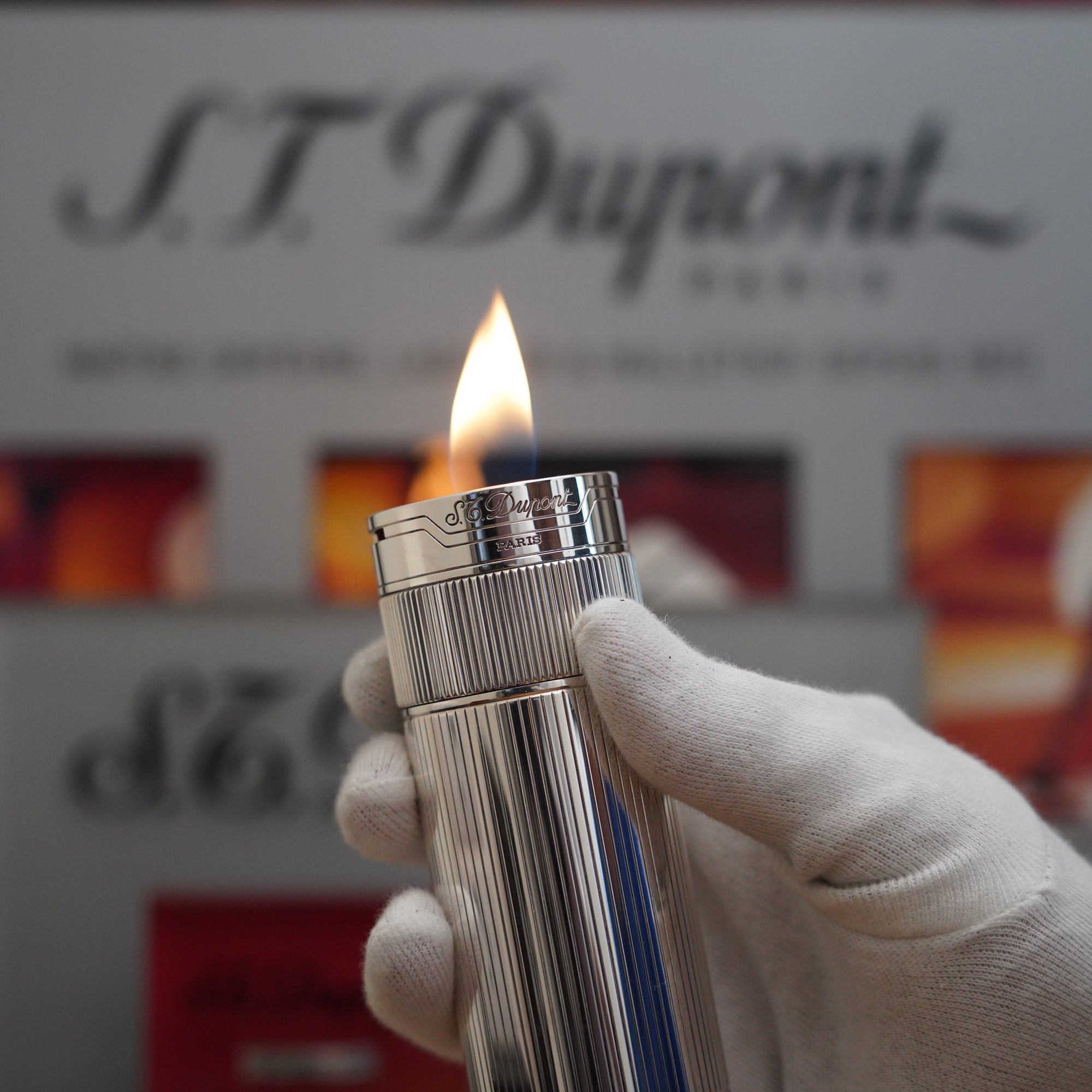 A person is holding a Vintage 1980 S.T. Dupont Unique Dual Flame Cylinder Silver Plated Table Lighter.