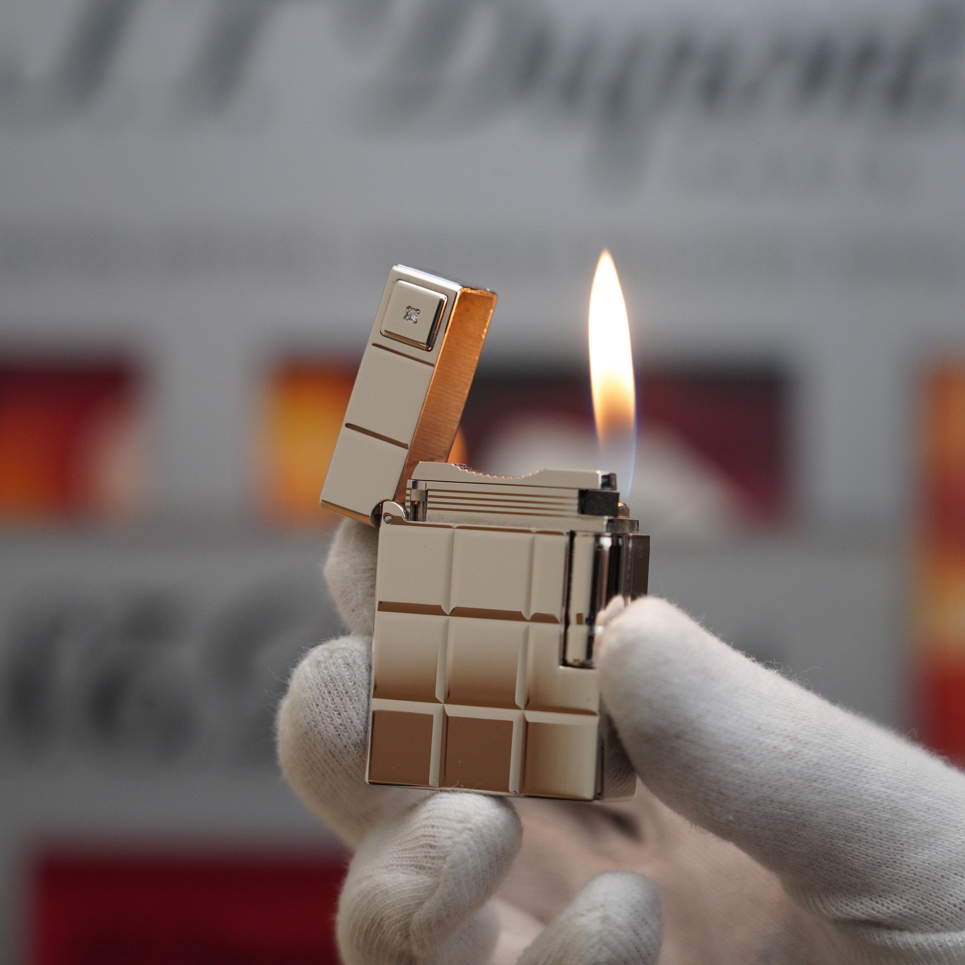 A person is holding a Vintage S.T. Dupont 1990 Limited anniversary Platinum Serie 60 years 1 Diamond Ligne 1 Plated Lighter with a gold bar on it.