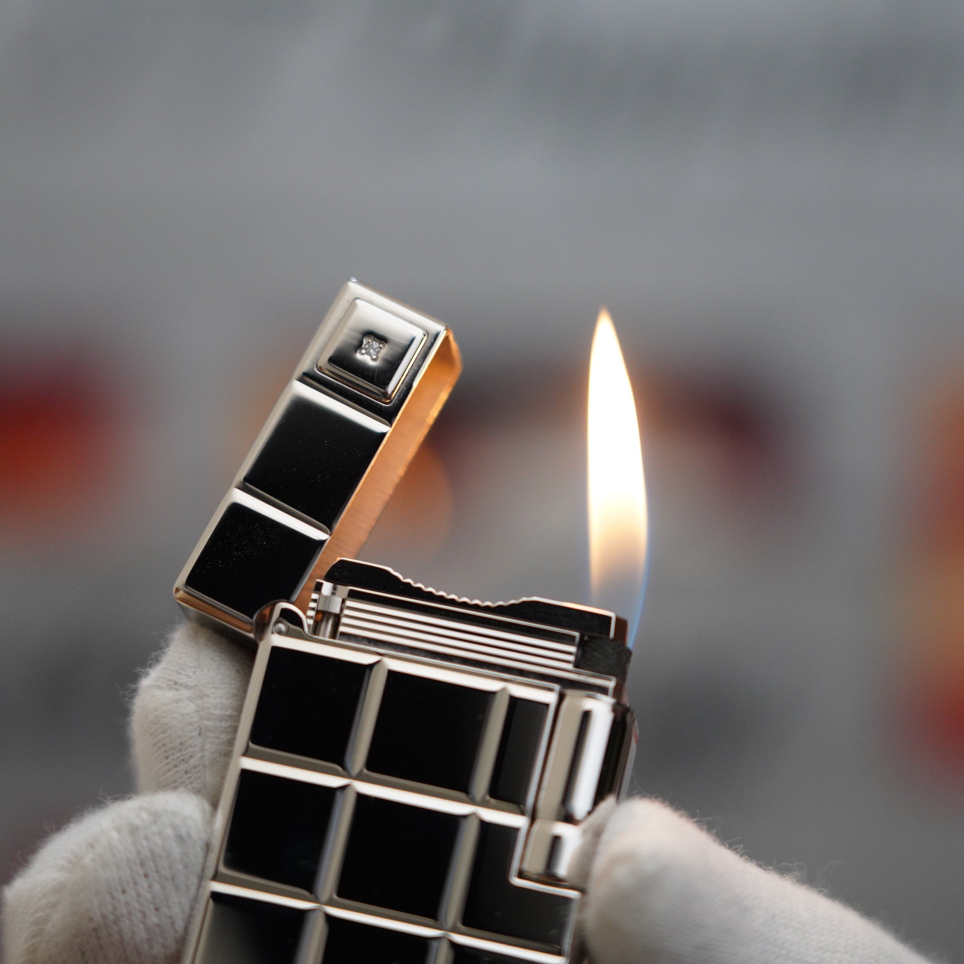 A person is holding a vintage S.T. Dupont 1990 Limited anniversary Platinum Serie 60 years 1 Diamond Ligne 1 Plated Lighter with a square design.