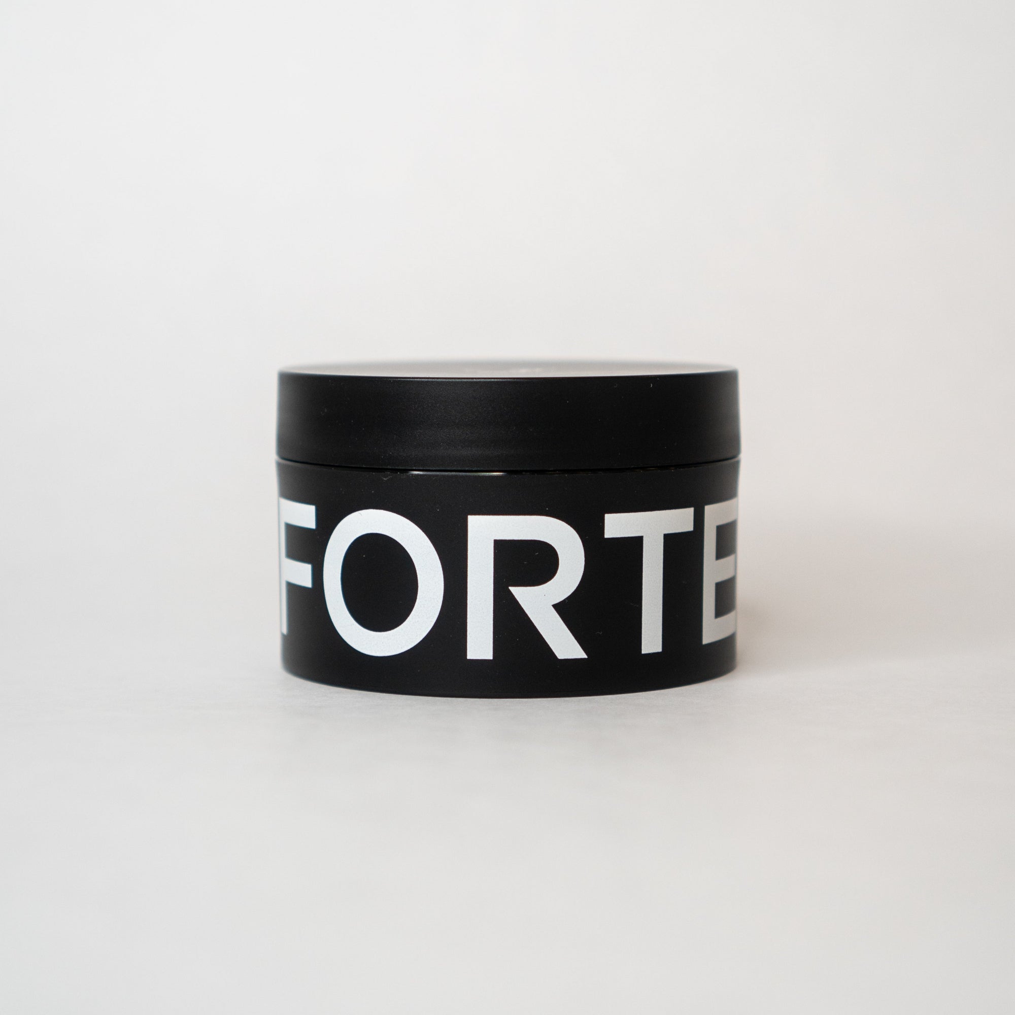 A nourished and healthy black tin with the word Forte Series Pomade by KirbyAllison.com on it, perfect for high volume hairstyles.