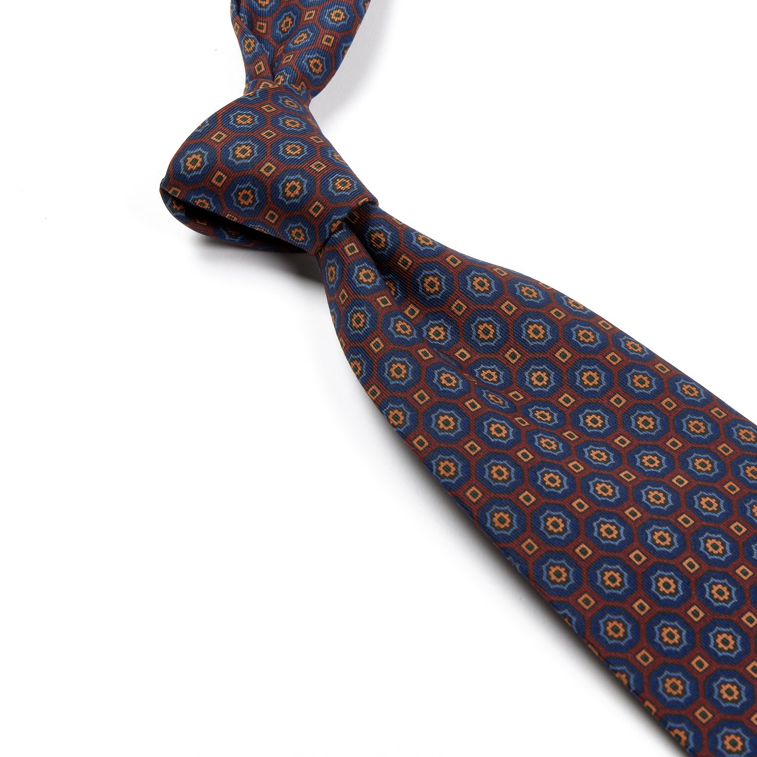 A Sovereign Grade Rust/Blue Floral Medallion Ancient Madder Tie handmade by KirbyAllison.com with a blue and orange pattern.