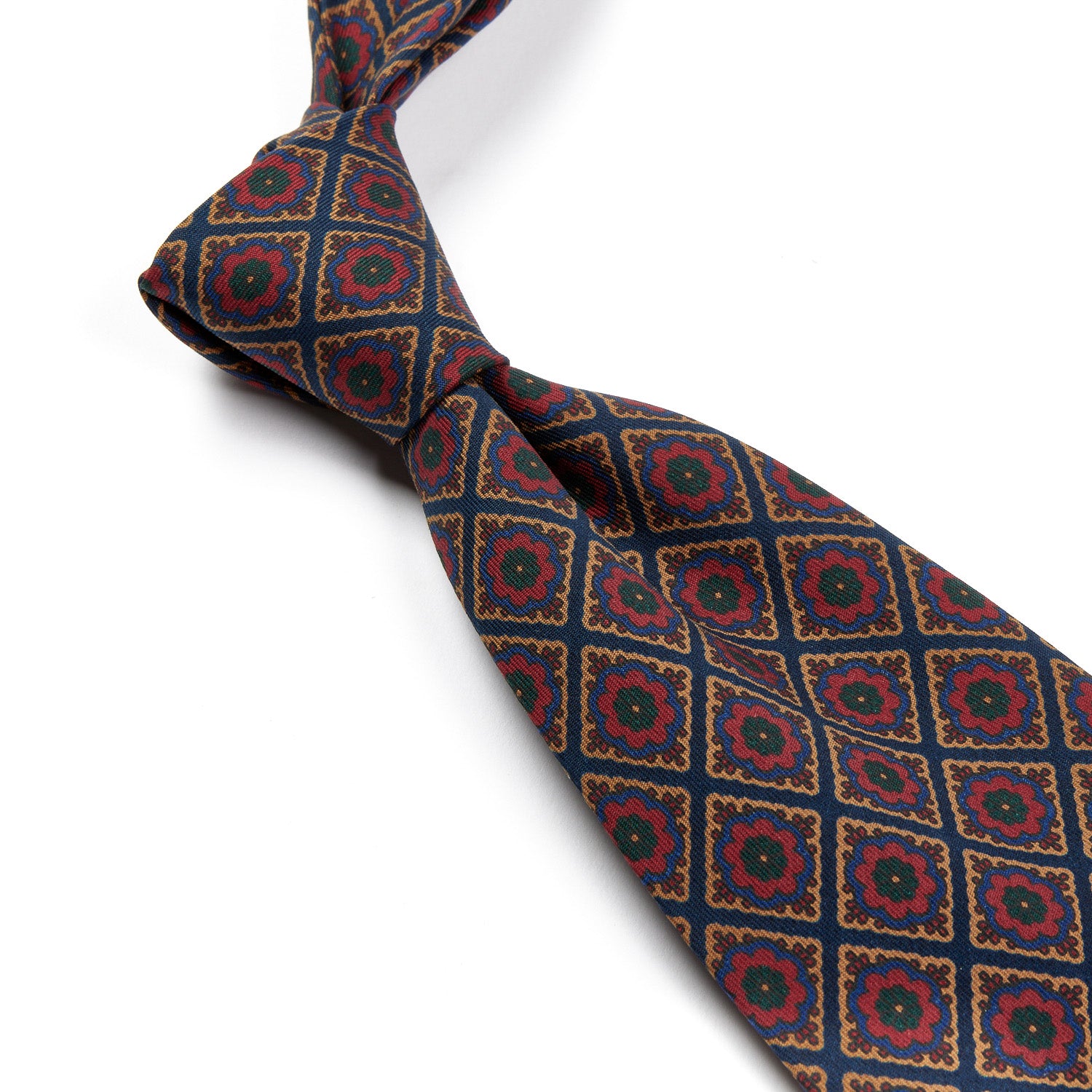 A Sovereign Grade Dark Navy/Red Oversized Medallion Ancient Madder Tie made by KirbyAllison.com with a red, green and blue pattern made of 100% English silk.