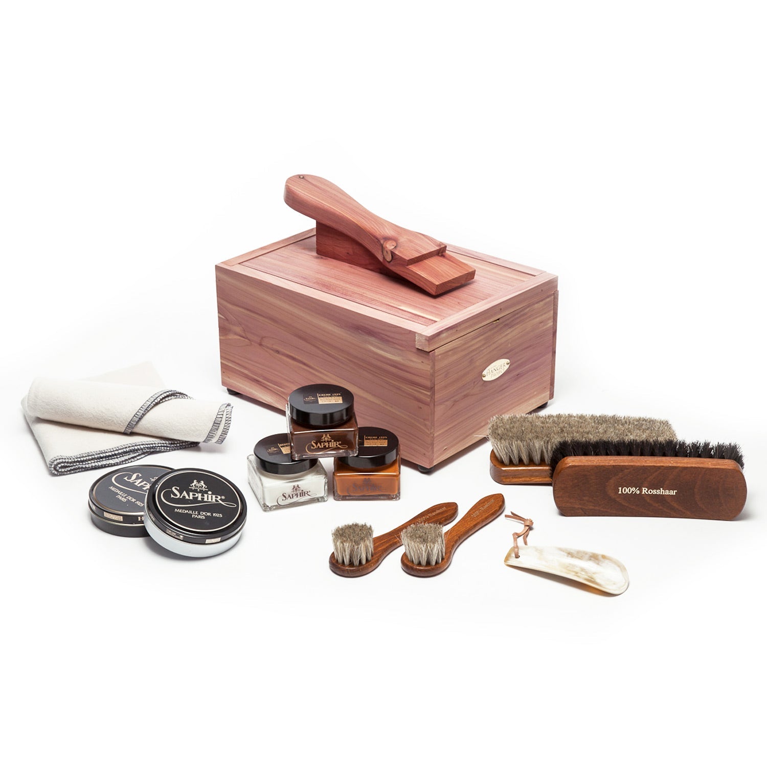 A wooden box with a Saphir Shoeshine Starter Kit (12 Piece Bundle) from KirbyAllison.com, including various polishes.
