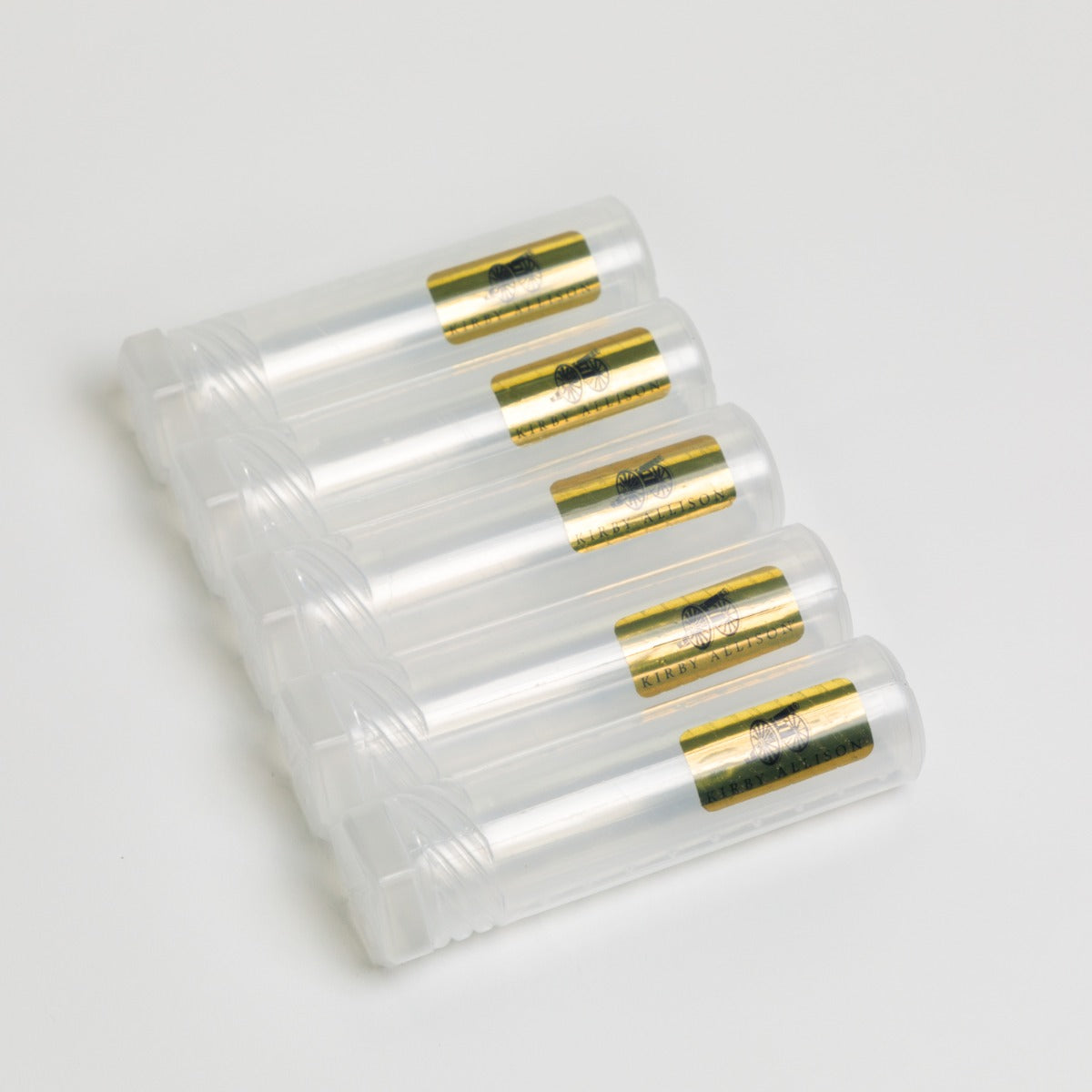 A group of Kirby Allison Plastic Cigar Storage Tubes (Set of 5) with gold lids on a white surface.