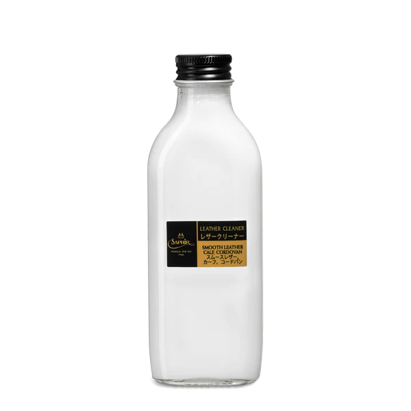A white milk bottle on a black background with Soletech Saphir Medaille d'Or Reno Leather Cleaner.