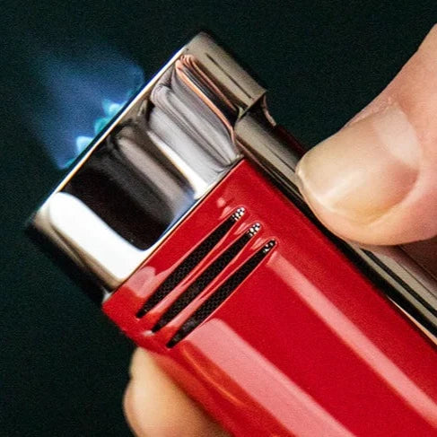 A person is holding an S.T. Dupont Red and Chrome Megajet Lighter in their hand.