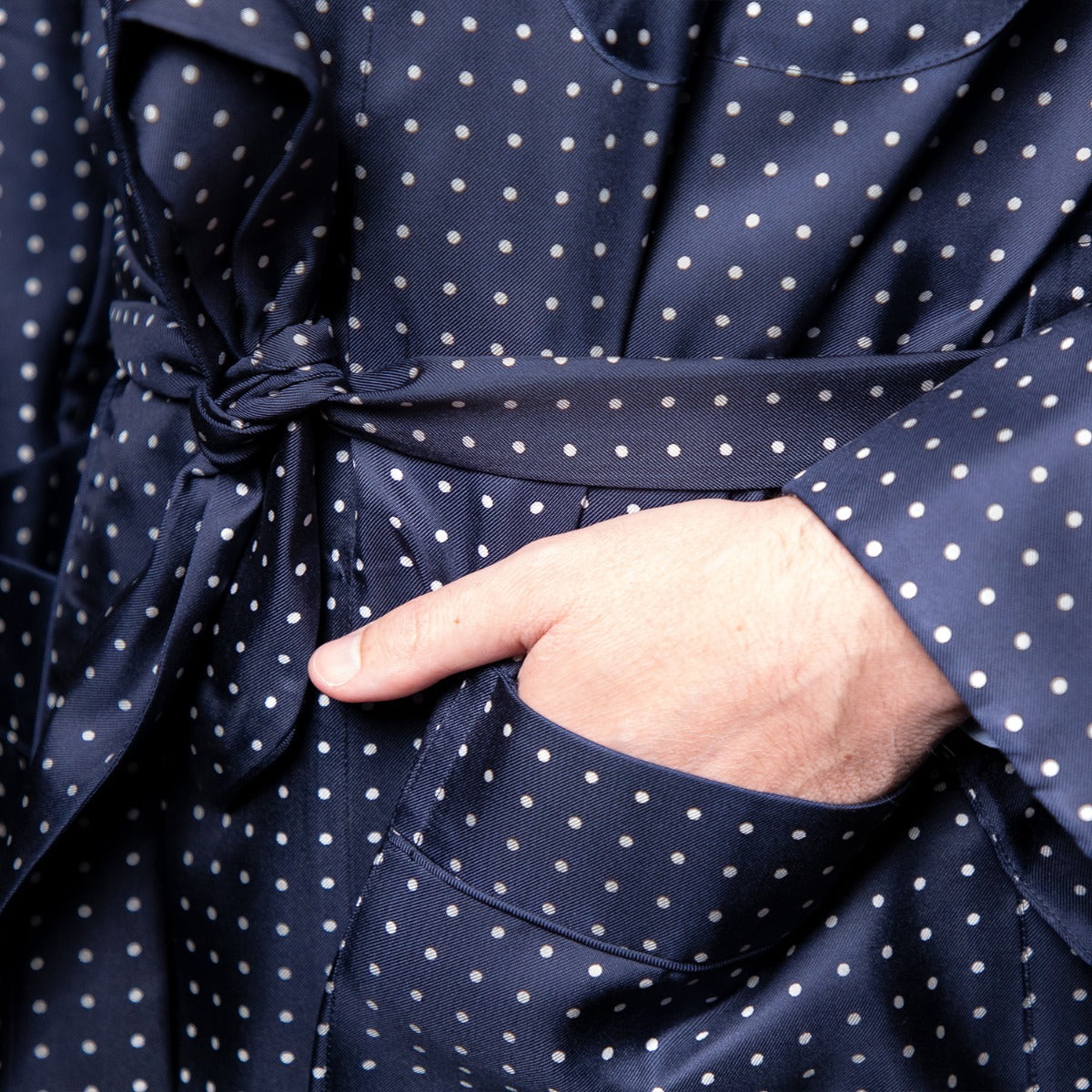 A man wearing a Sovereign Grade Navy London Dot Dressing Gown from KirbyAllison.com.
