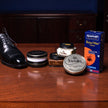 A comprehensive collection of KirbyAllison.com's Saphir Presidential Shoeshine Starter Kit (7 Piece Bundle) including shoe polish on a table.
