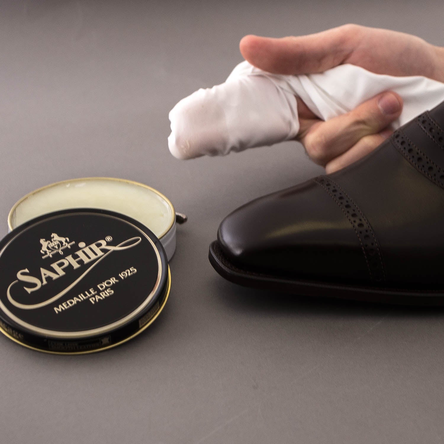 A person using the Wellington High-Shine Cotton Chamois from KirbyAllison.com to achieve a high-shine on a shoe.
