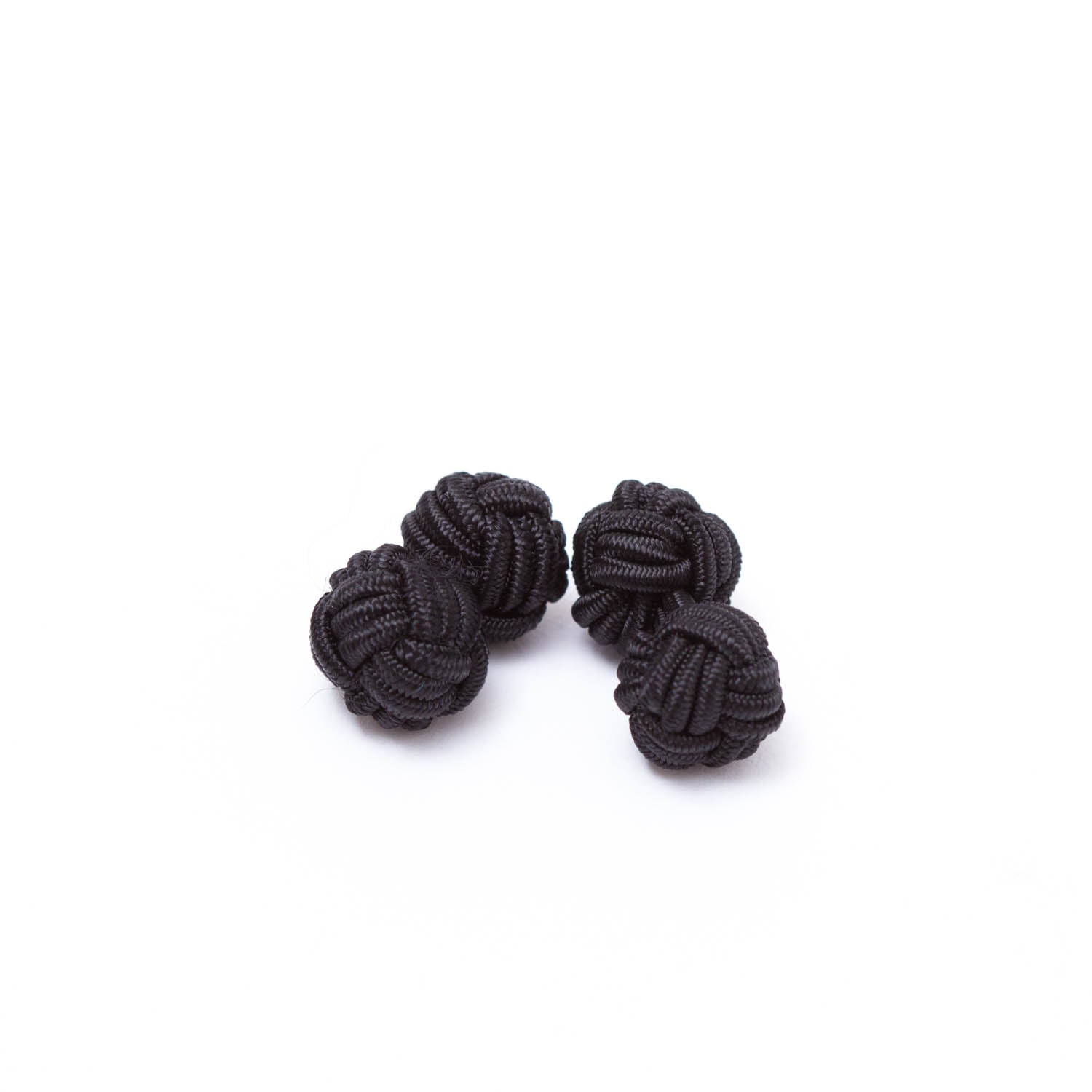 Four handmade black Solid Knot Cuff Links on a white surface. (Brand: KirbyAllison.com)
