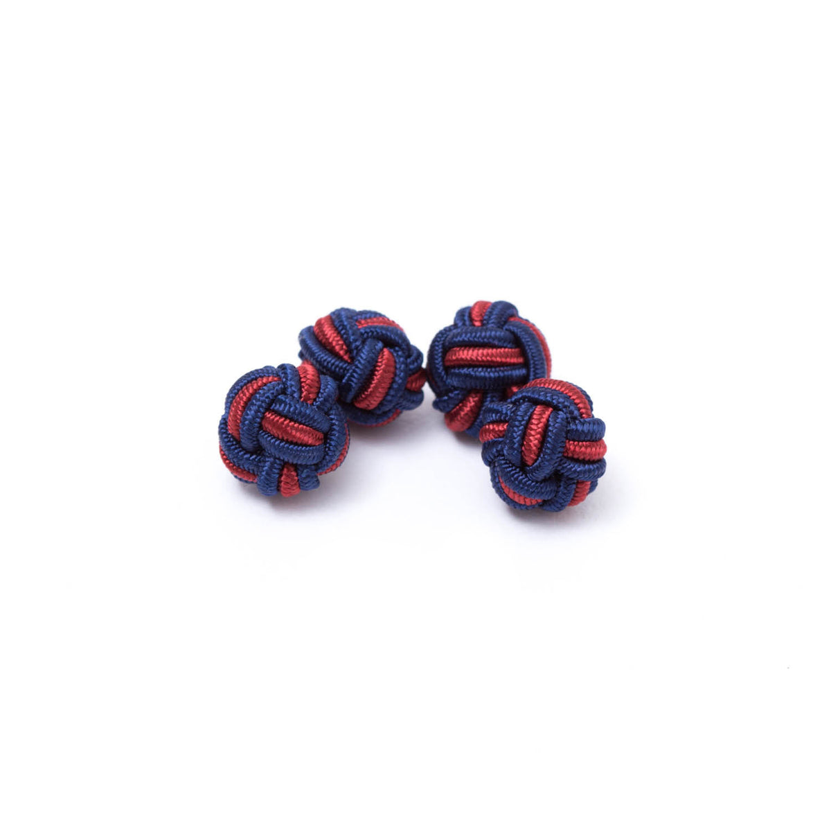 A pair of Dual Colored Knot Cufflinks, one blue and one red, on a white background from KirbyAllison.com.