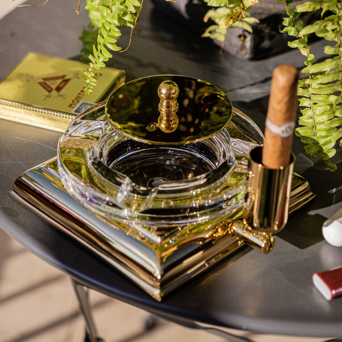 An El Casco Executive Cigar Ash Tray (Gold) on a table.