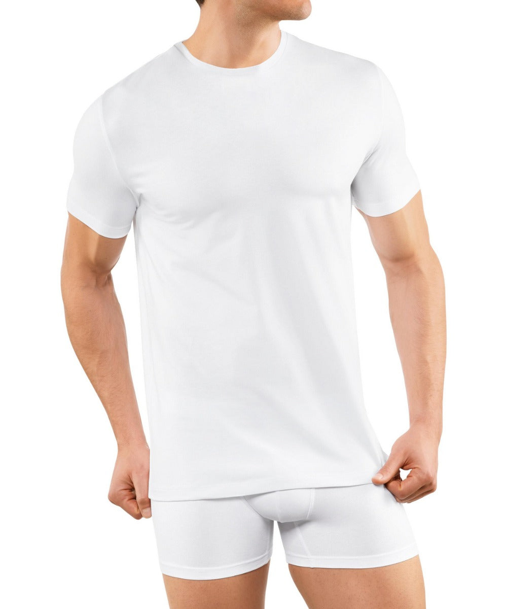 A man wearing a Falke Men Underwear Crew Neck T-Shirt 2-Pack from KirbyAllison.com, made of Egyptian cotton and in white color.