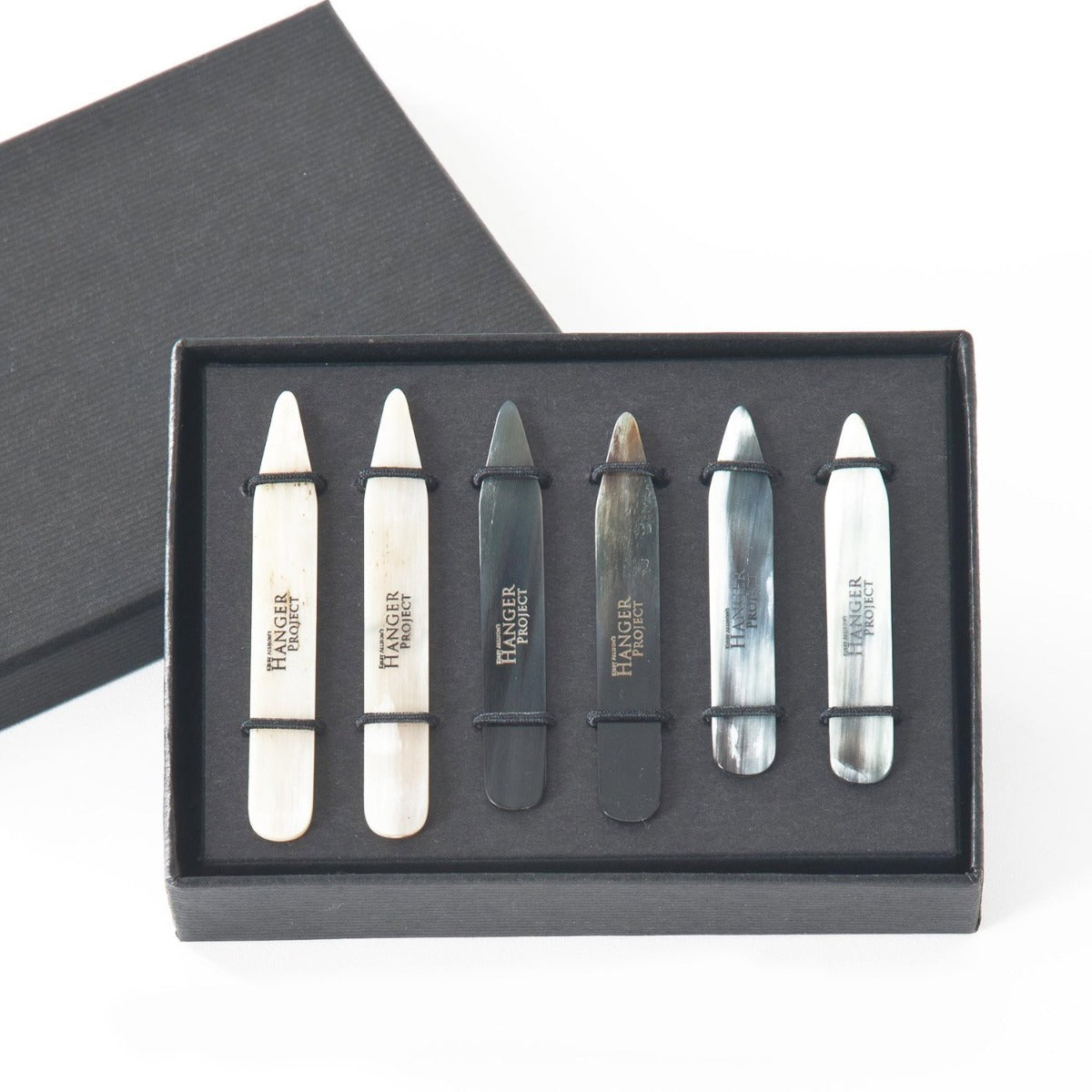 A set of black and white toothpicks in a black box with Kirby Allison Horn Collar Stays.