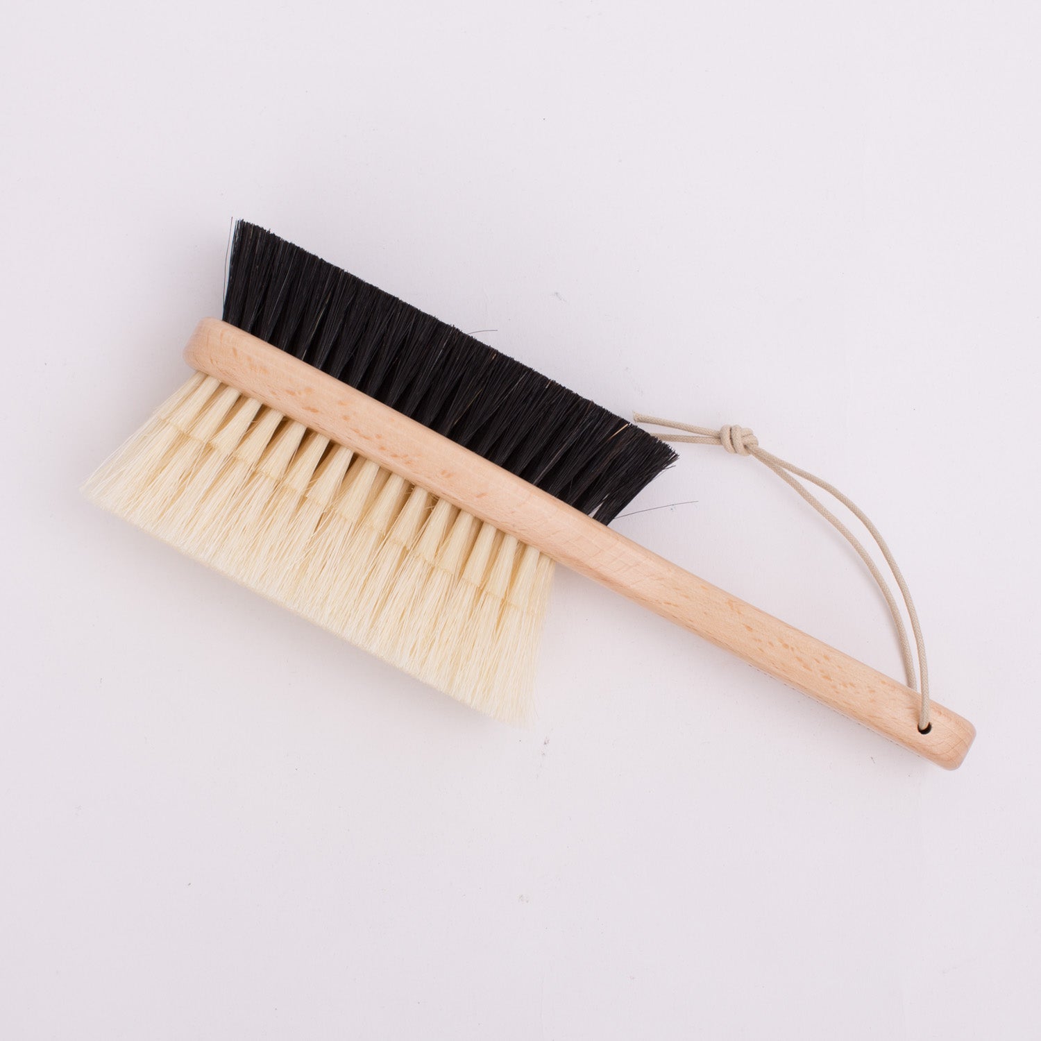 A KirbyAllison.com Deluxe Double-Sided Garment Brush with black and white bristles.