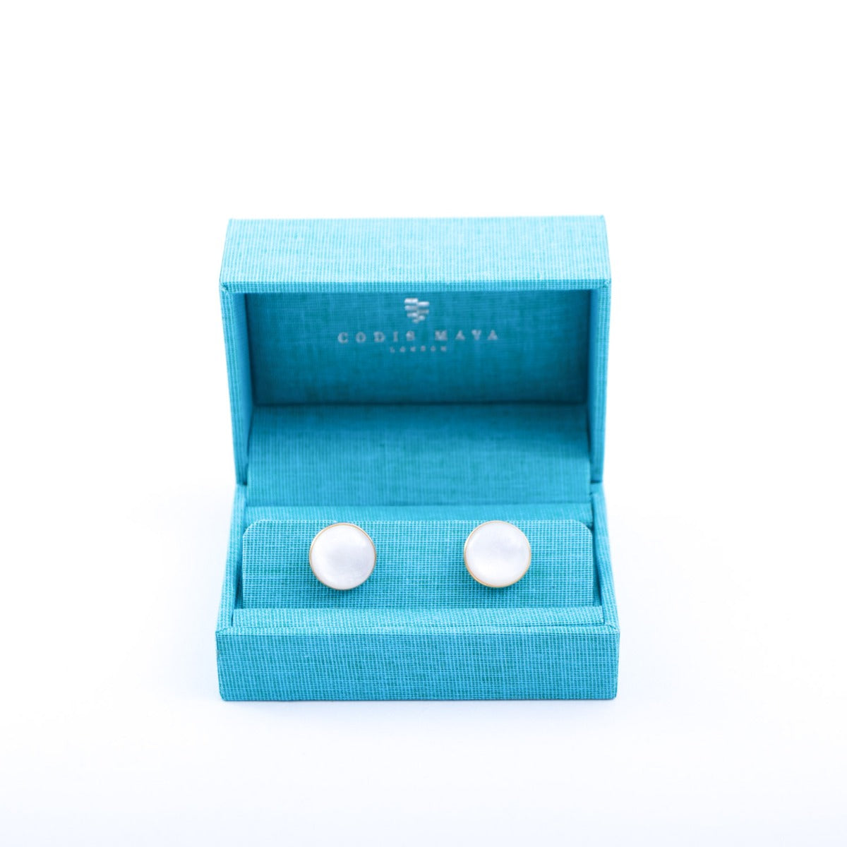 A pair of Indonesian Mother of Pearl Gold Stone Capsule Cufflinks from KirbyAllison.com in a blue box.