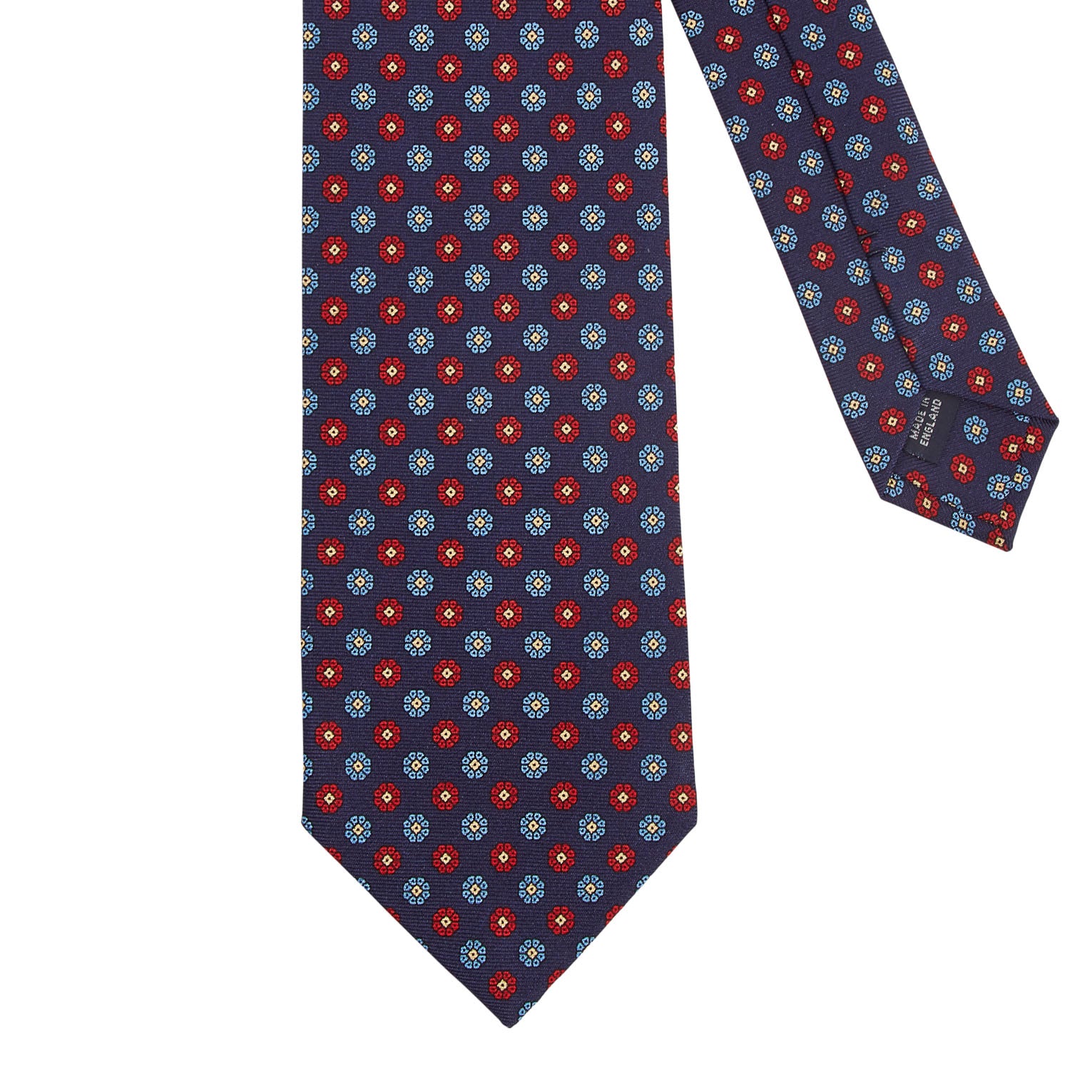 A high-quality, handmade Sovereign Grade Macclesfield Corn Floral Motif Tie from KirbyAllison.com with blue circles.