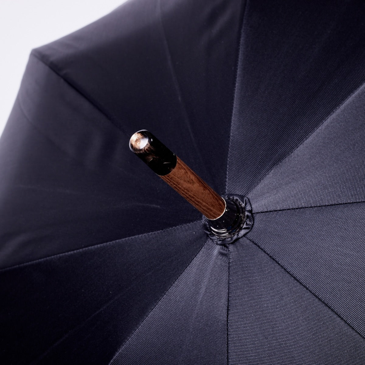 A KirbyAllison.com brown pigskin solid stick umbrella with a black canopy.