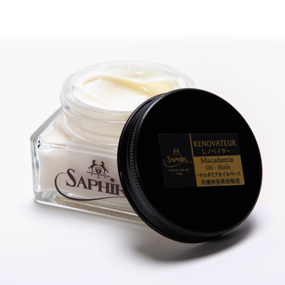 A jar of Saphir Renovateur w/ Macadamia Oil conditioner next to a white surface by KirbyAllison.com.