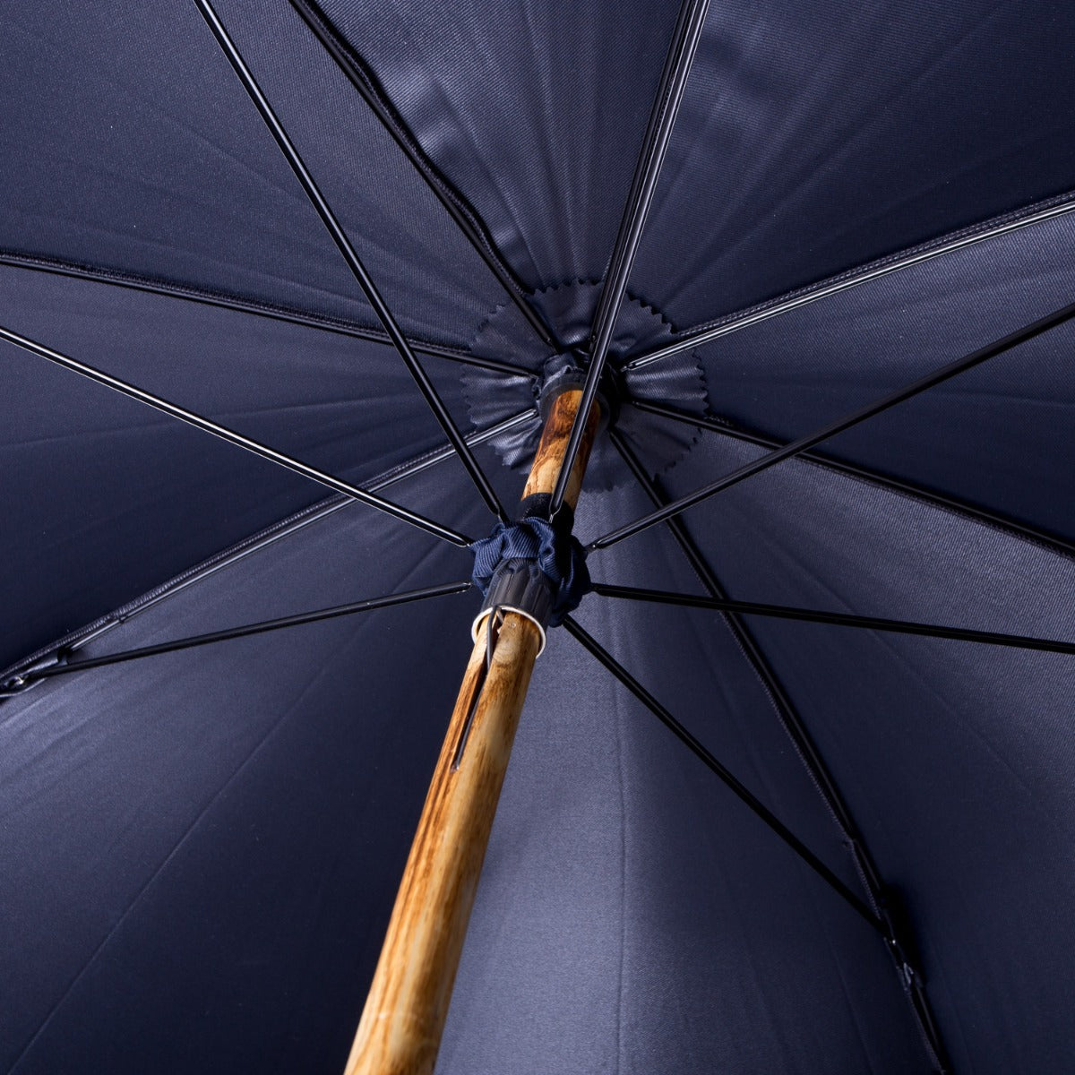 A KirbyAllison.com Ashwood Solid Stick Umbrella with Navy Canopy, a gentleman's umbrella with a solid-stick wooden handle.