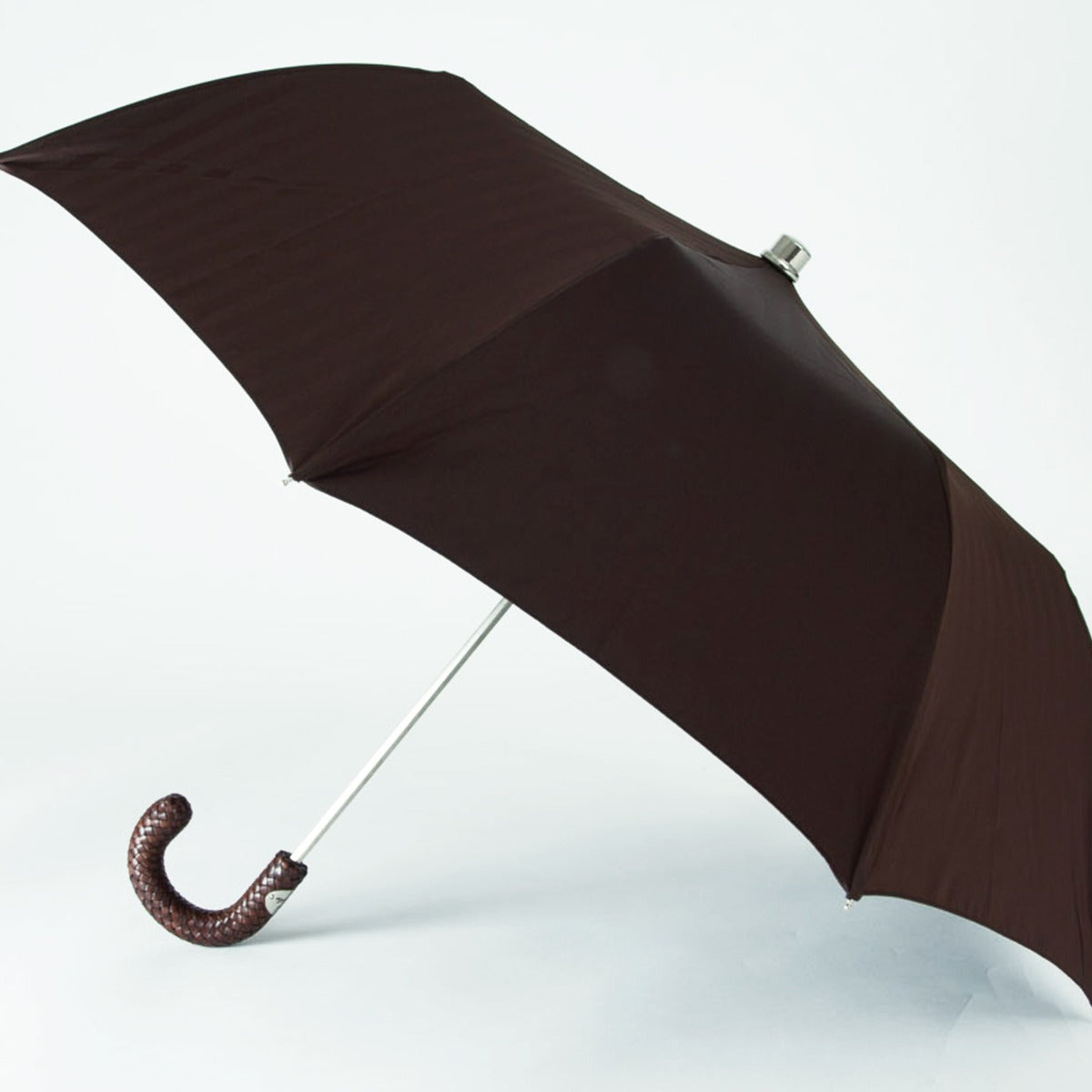 A handcrafted Brown Herringbone Canopy Travel Umbrella with a woven leather handle on a white background by KirbyAllison.com.