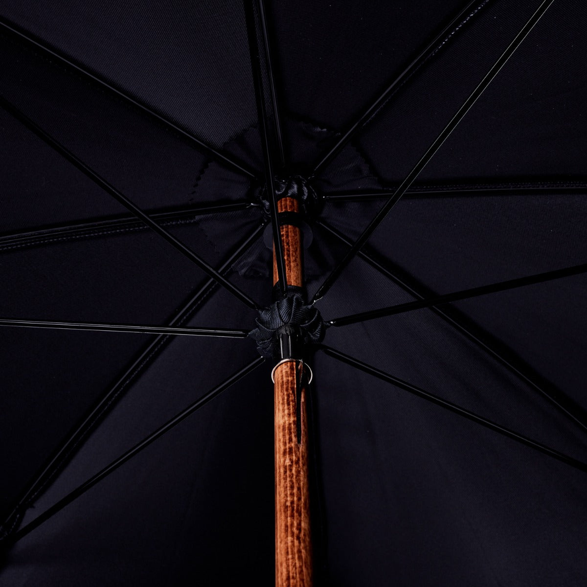 A black Bamboo Handle Umbrella with a wooden handle and KirbAllison.com construction.